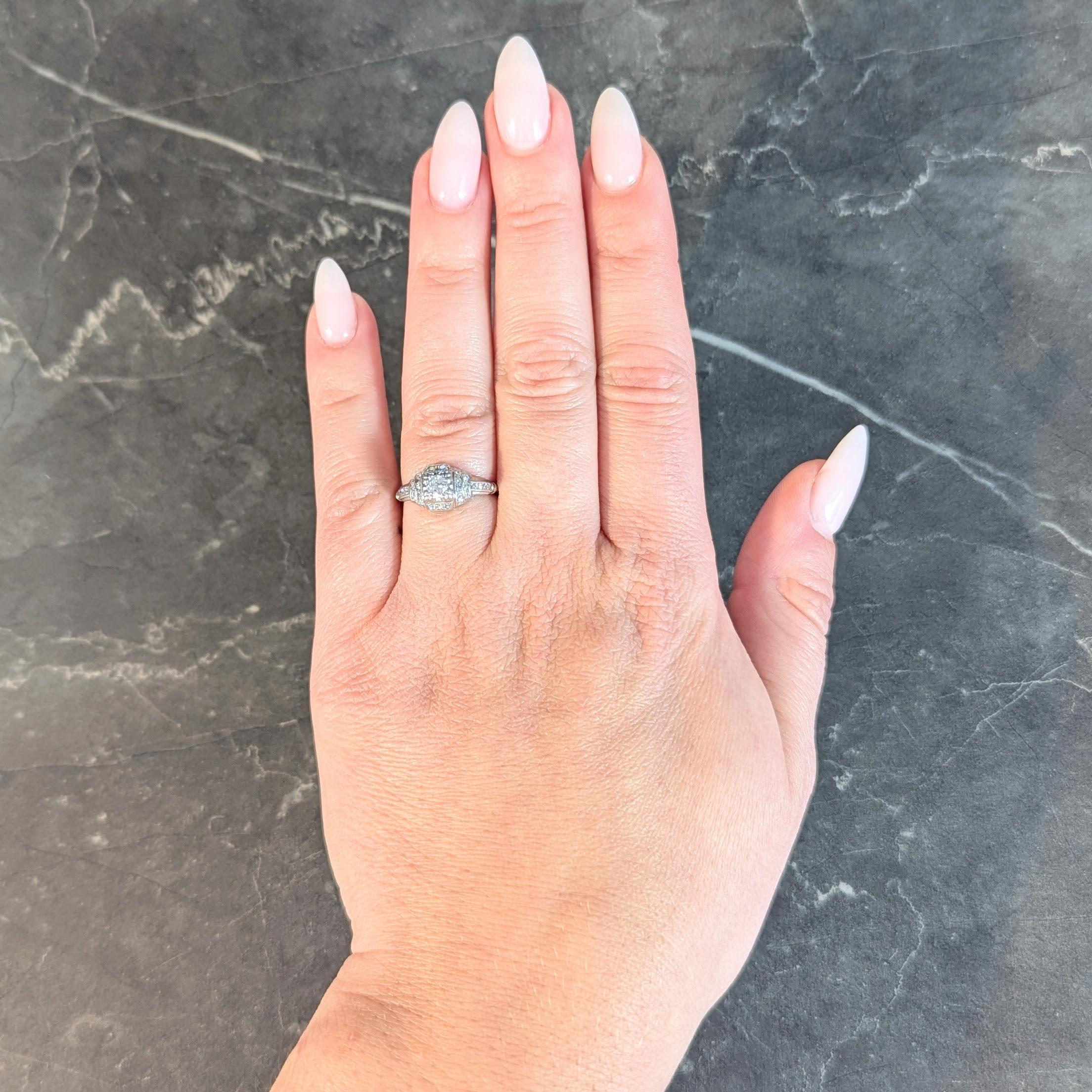 Centering an old European cut diamond weighing approximately 0.16 carat total
G color with VS2 clarity - set with tri-split prongs in a square form head
With a stepped bombé surround and grooved shoulders
Bead and channel set with single cut
