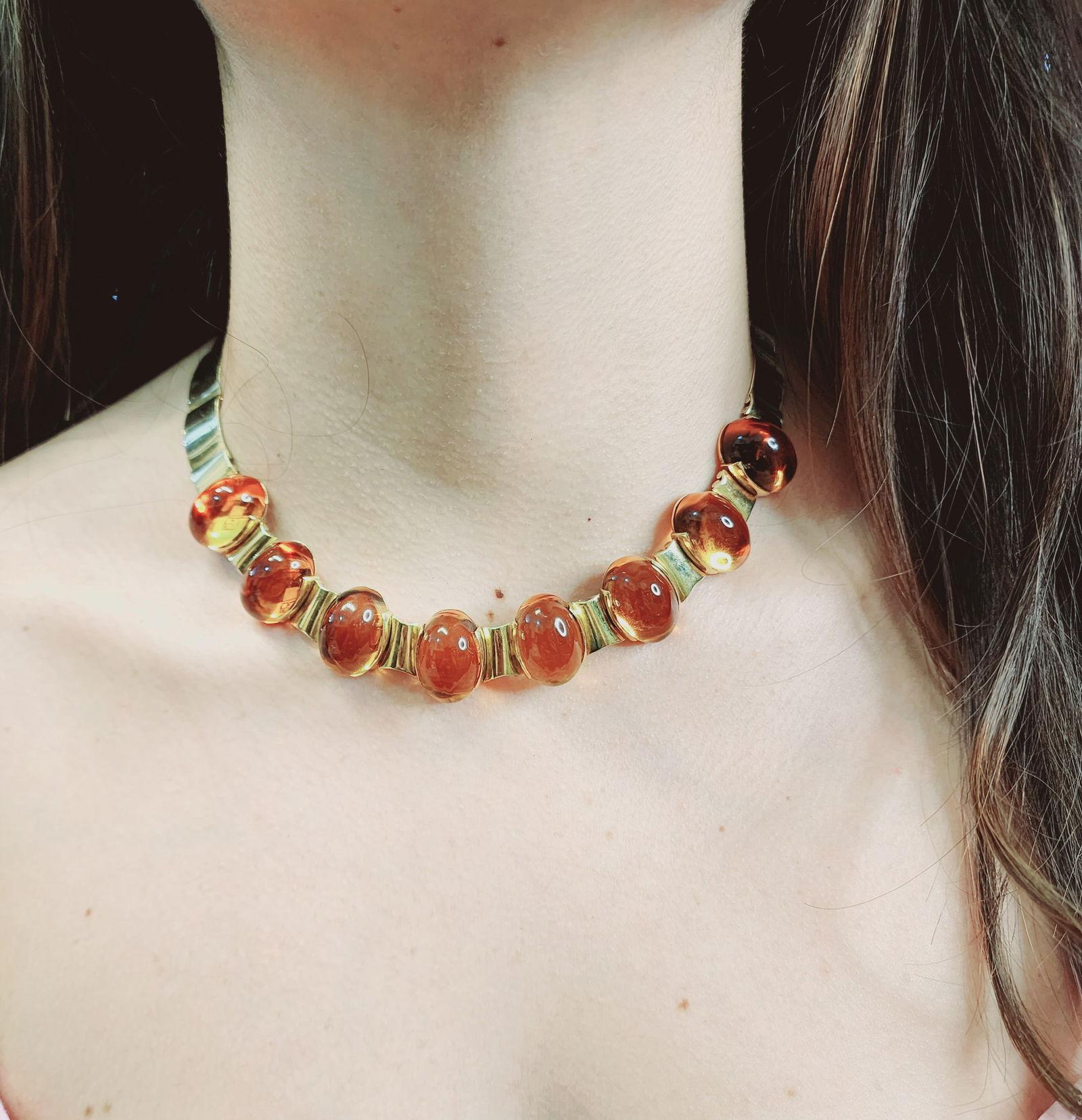 Remontez le temps avec cet exquis collier vintage, circa 1950, réalisé en luxueux or jaune 18k et orné de huit citrines naturelles en cabochon pesant ensemble environ 158 carats. Cette pièce d'apparat dégage un charme rétro et une élégance