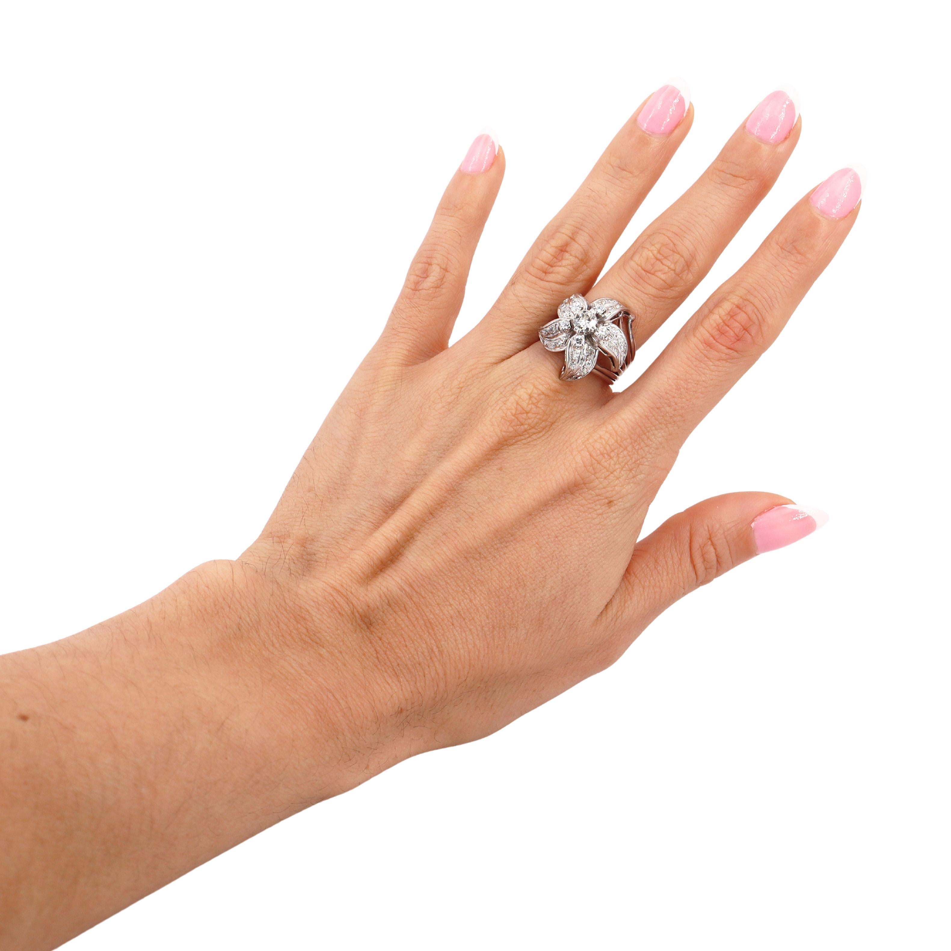 An exquisite creation from the 1950s Retro era, this flower-inspired ring is masterfully crafted in platinum, showcasing both timeless elegance and exceptional craftsmanship. At its heart lies a brilliant round-cut diamond, weighing