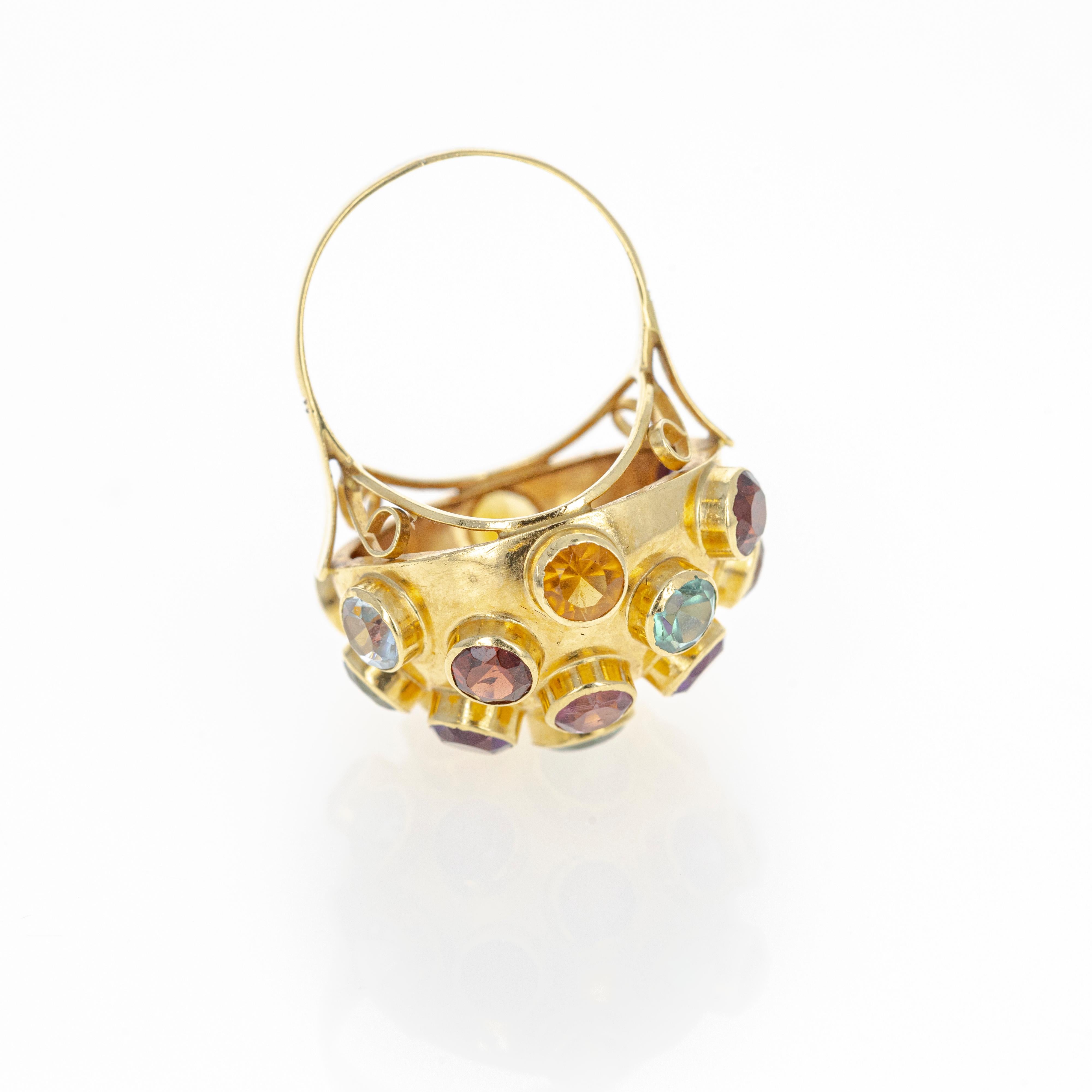 Era : Retro Estate(1950's)
Composition : Or jaune 18K
Pierre principale : Améthyste, grenat, citrine, topaze bleue, prasiolite et tourmaline de forme ronde et naturelle. Dix-neuf pierres au total.
Taille de l'anneau : 7
Poids de l'anneau : 5,6