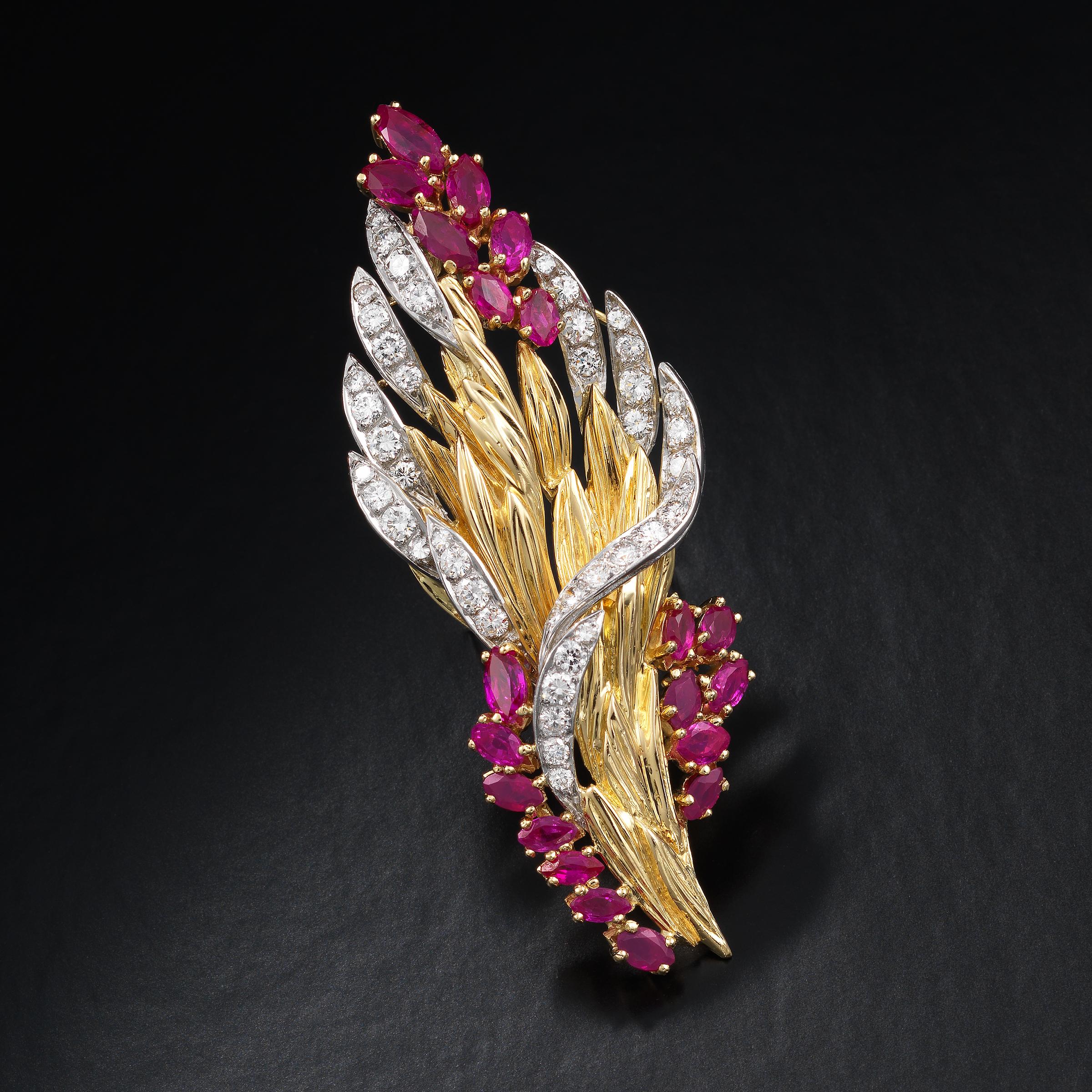 Elegant retro brooch modelled in the form of an enchanting flower bouquet of shimmering gold leaves, glowing ruby flower buds, and glittering diamond accents. The central part of the brooch is rendered in 18 karat yellow gold which is also the