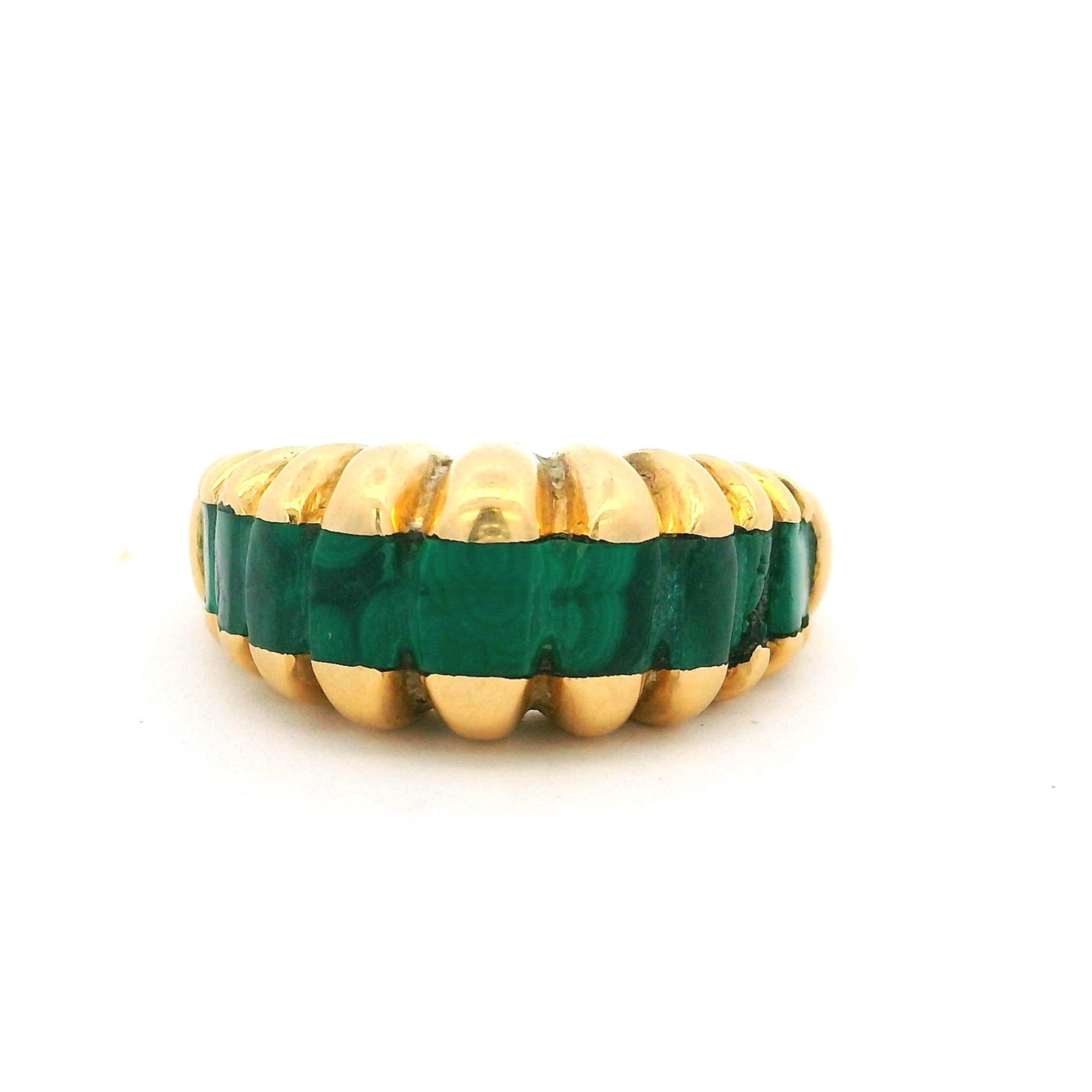 Questo sorprendente anello a cupola scultorea retrò anni '80 è realizzato in oro giallo massiccio 18 carati e incastonato con pannelli di malachite intagliata dalle tonalità intense. Le bande naturali della malachite e i toni verdi profondi sono