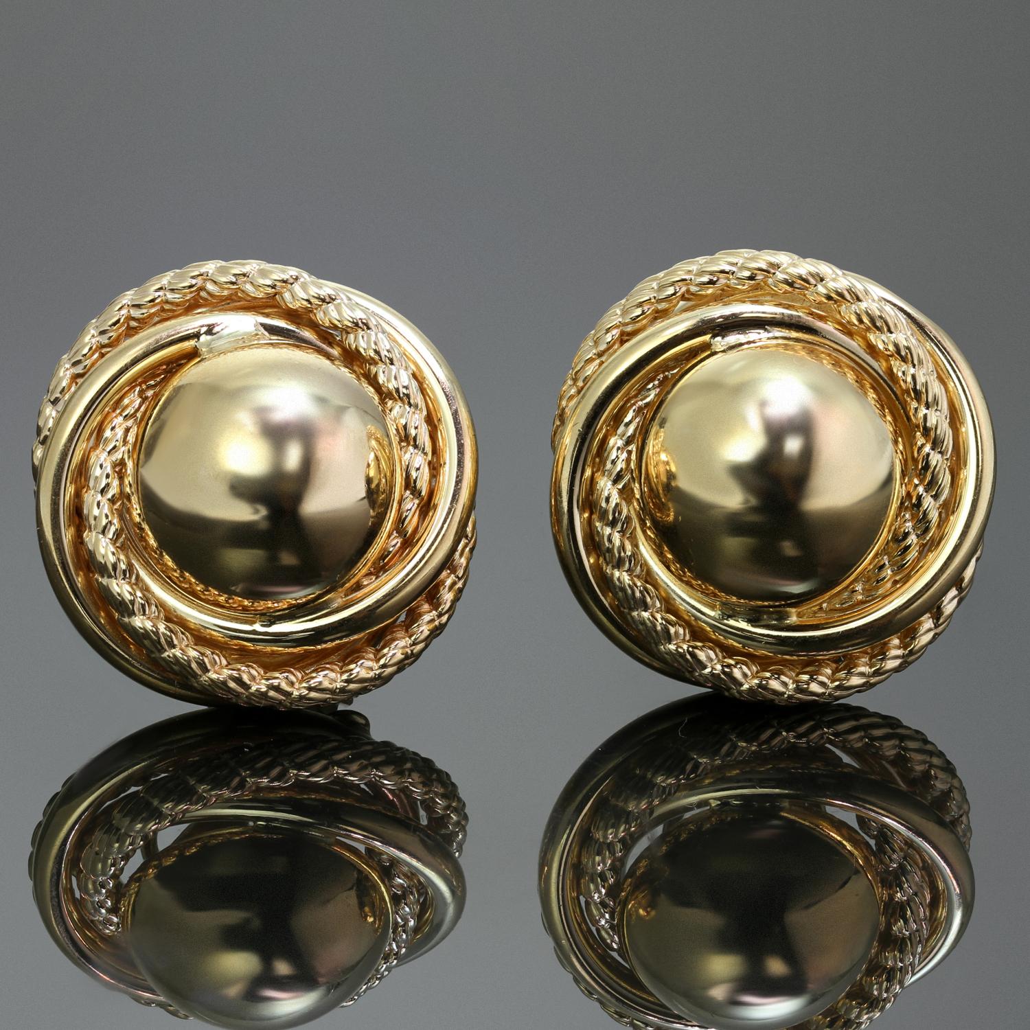 These elegant retro lever-back earrings are crafted in 14k yellow gold and feature a round dome button design surrounded by a polished and textural swirling elements. Made in United States circa 1980s. Measurements: 1.02