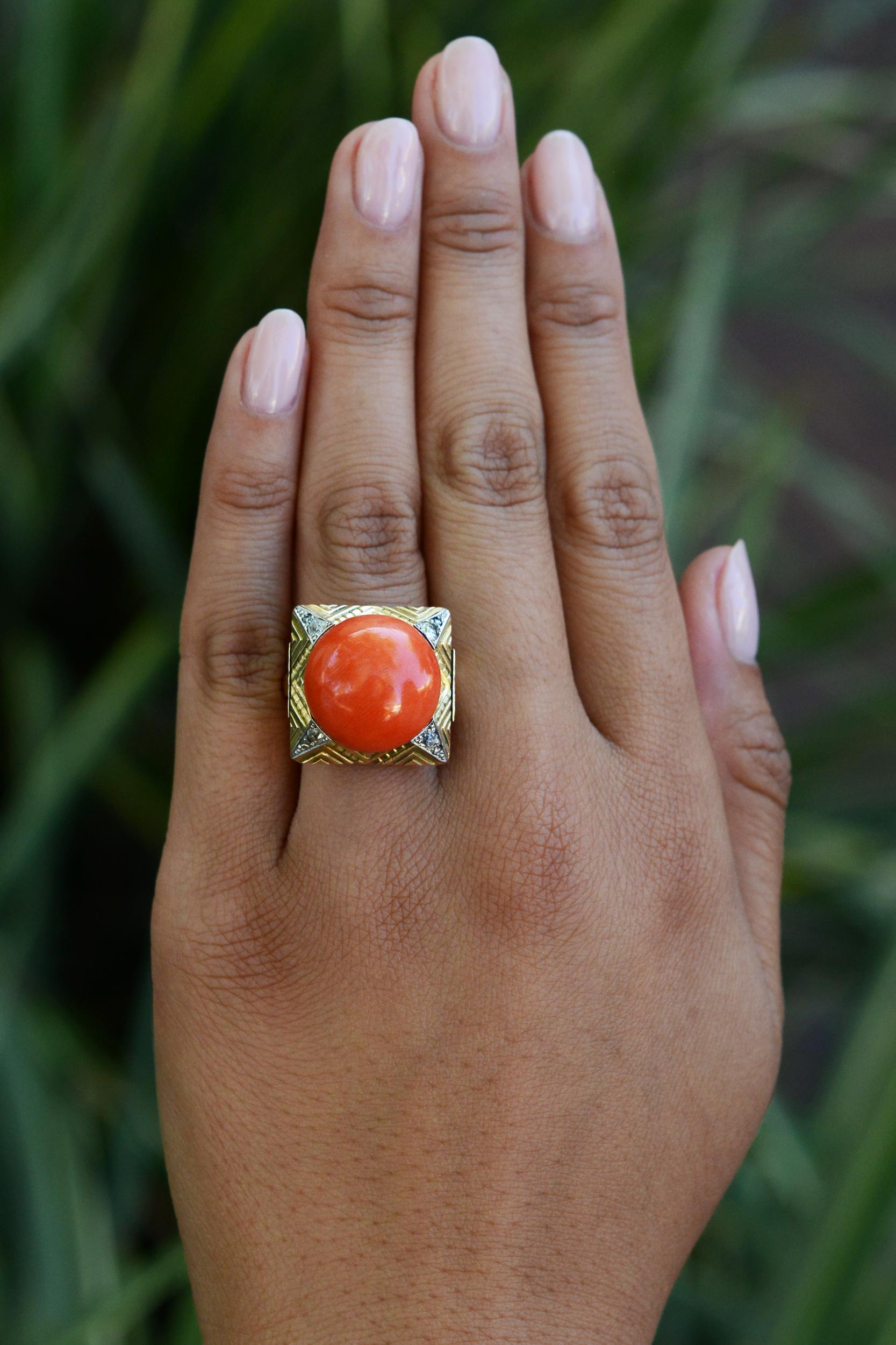 This 1940s vintage late Art Deco-Retro era cocktail ring is a resplendent and glittering jewel. Featuring a large cabochon coral weighing over 20 carats, geometrically accented with sparkling natural diamonds. Natural Coral gemstones are held to the
