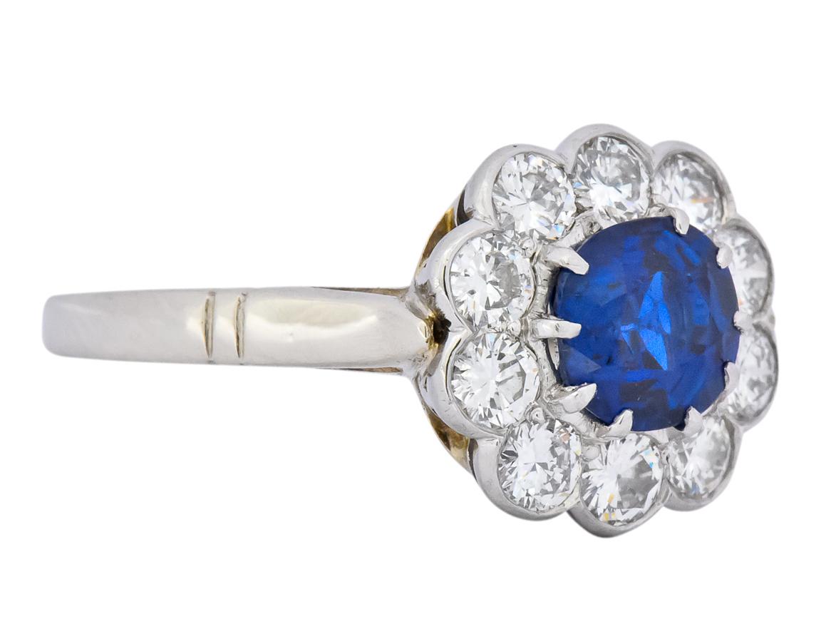 Cathedral style cluster ring centering a claw set oval brilliant cut sapphire weighing approximately 1.09 carat, medium-dark royal blue with no indication of heating

Surrounded by ten bezel set round brilliant cut diamonds weighing approximately