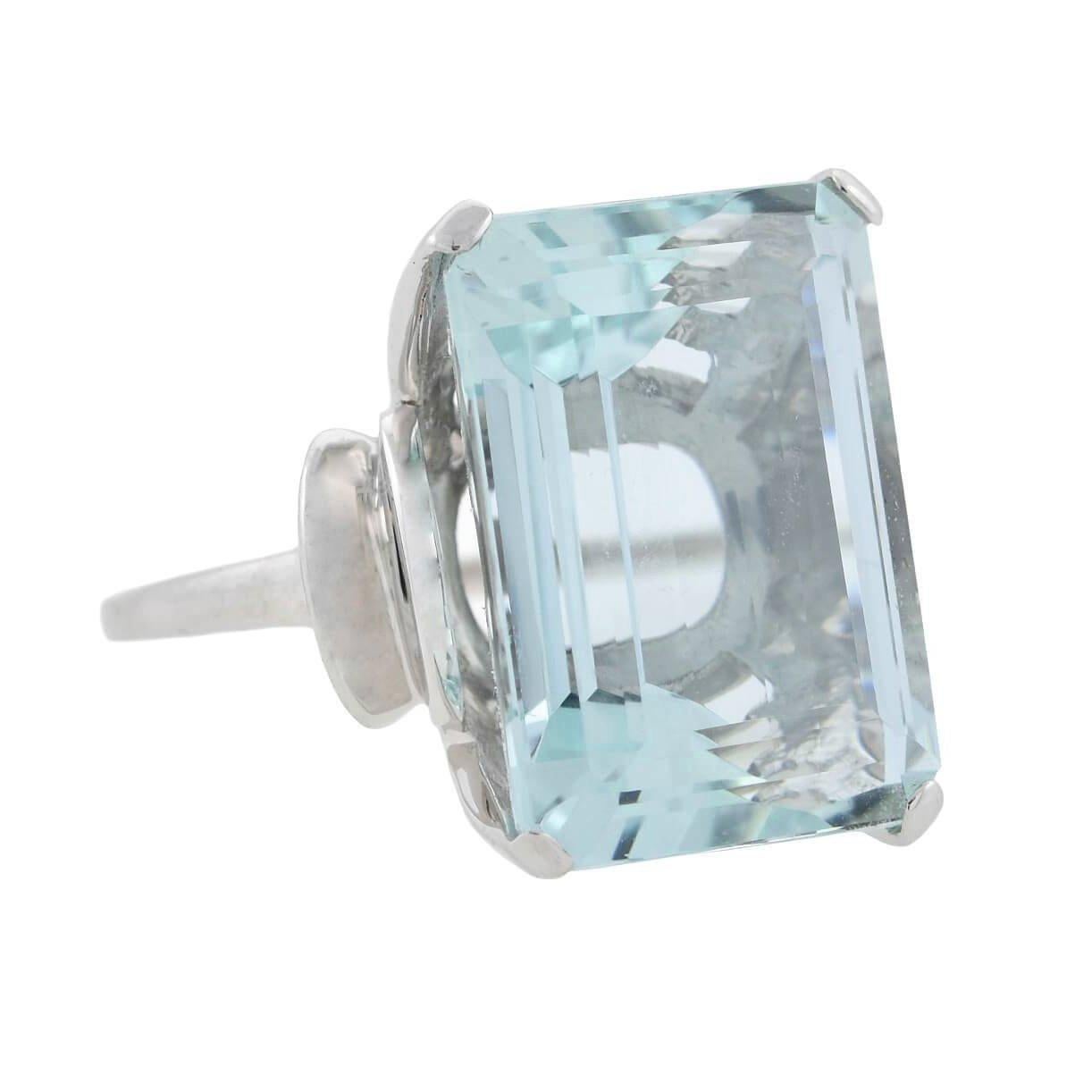 A showstopping aquamarine cocktail ring from the Retro (ca1940s) era! Crafted in 14kt white gold, this fabulous piece adorns a substantial, Emerald Cut aquamarine stone. The prong set stone weighs approximately 21.35ctw and displays an incredibly