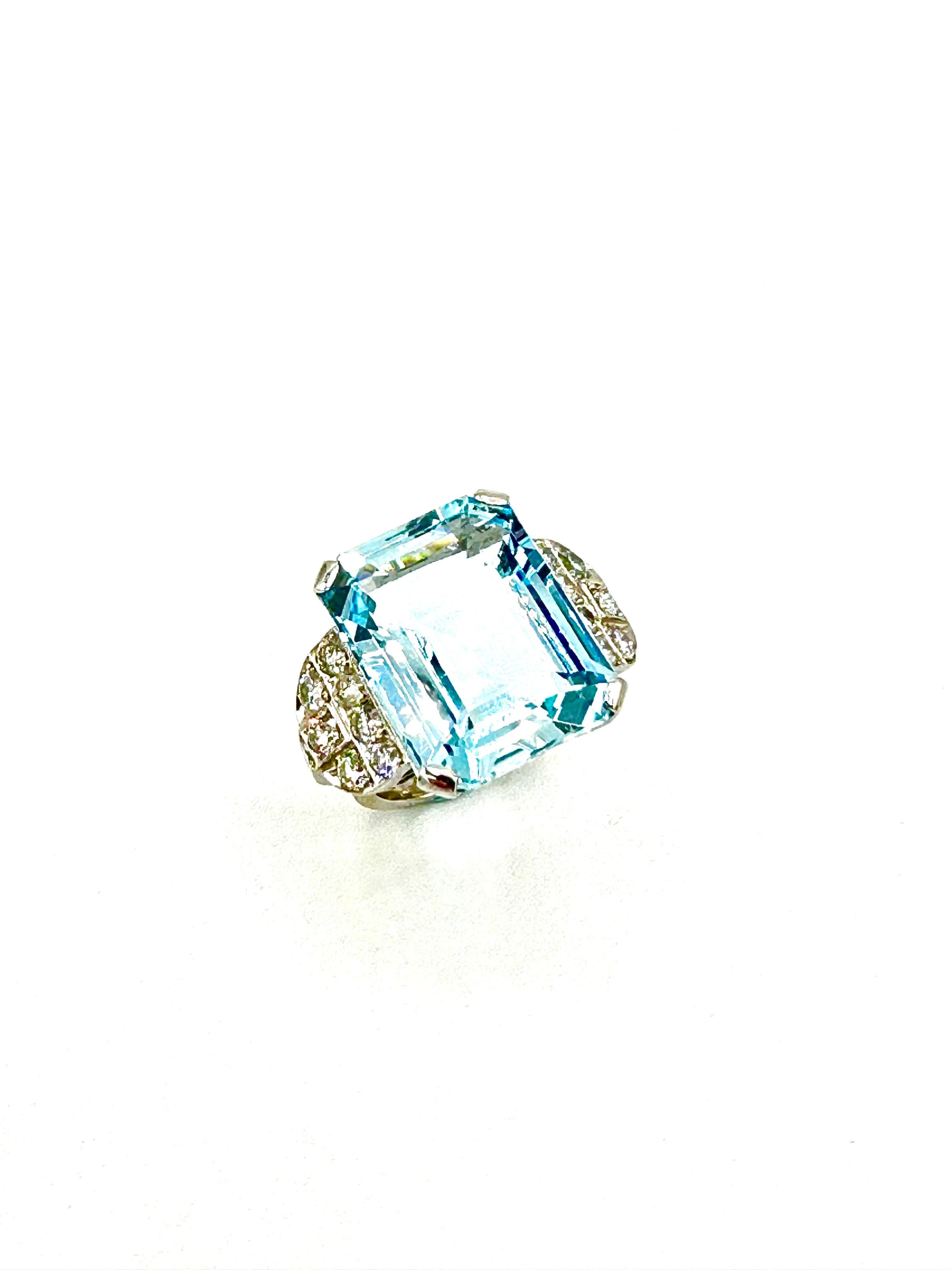 Dive in to the stunning beauty of this Retro Aquamarine cocktail ring.  The emerald cut Aquamarine has a weight of 21.67 carats, set in four wide prongs at the corners, with a cluster of eight round brilliant Diamonds on each side of the Aquamarine.