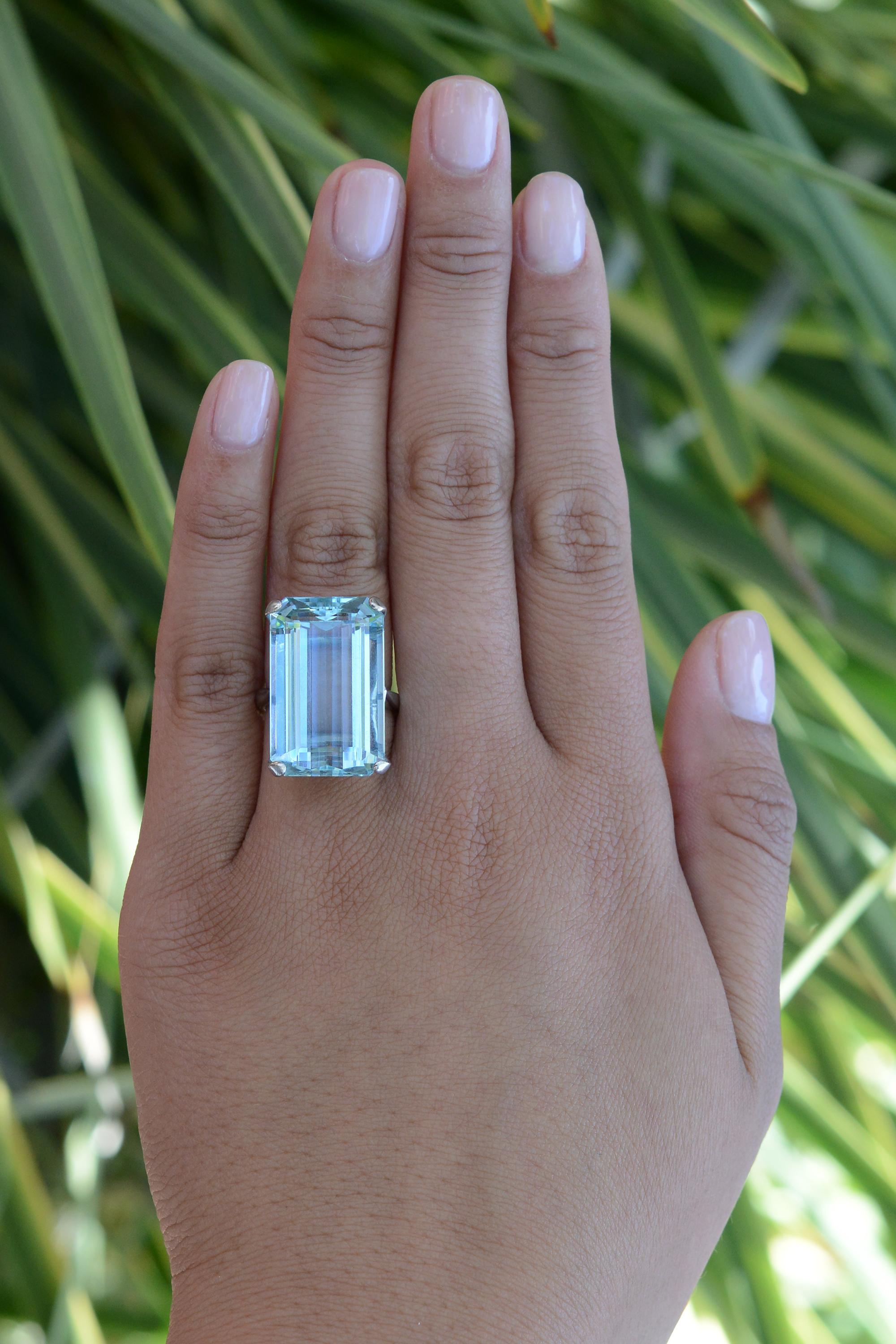 This 1940s Retro cocktail ring showcases an impressive 22 carat emerald-cut aquamarine boasting a deeply saturated and vibrant glacial blue color. An iconic jewel, the aquamarine gemstone has a with a rich history of being carried as a symbol of