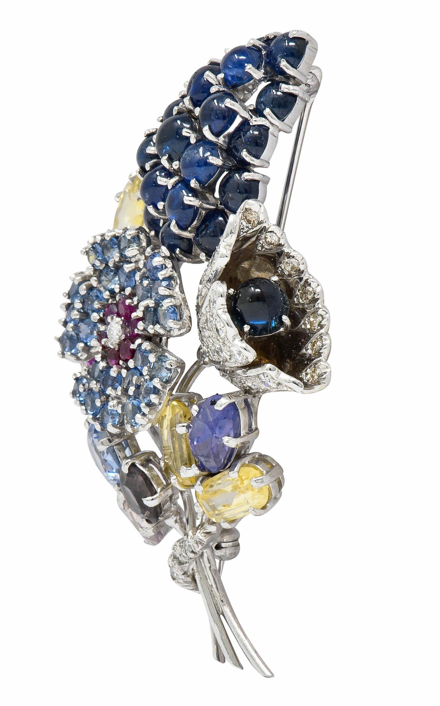 Brooch is designed as various florals comprised of diverse hues of sapphires

Featuring round cut cabochon, cushion, round, and hexagonal cuts that weigh in total approximately 25.00 carats

Pavè set and accented by single and round brilliant cut