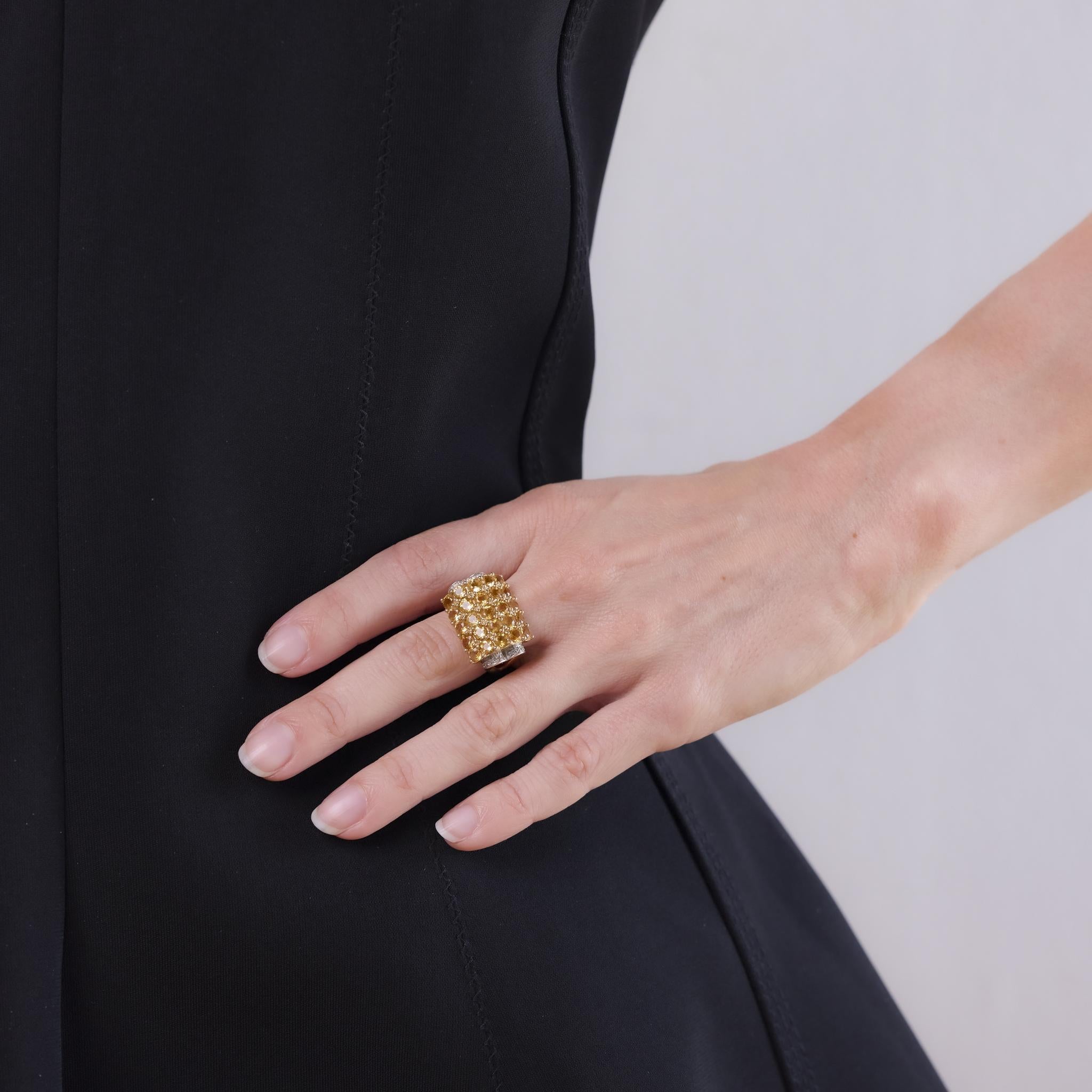 This Retro ring from the 1940s is crafted in 14k yellow gold and features 25 round brilliant cut citrines totaling approximately 3.25 carats. Accenting the vibrant citrines are 16 round brilliant cut diamonds totaling approximately 0.10 carats,
