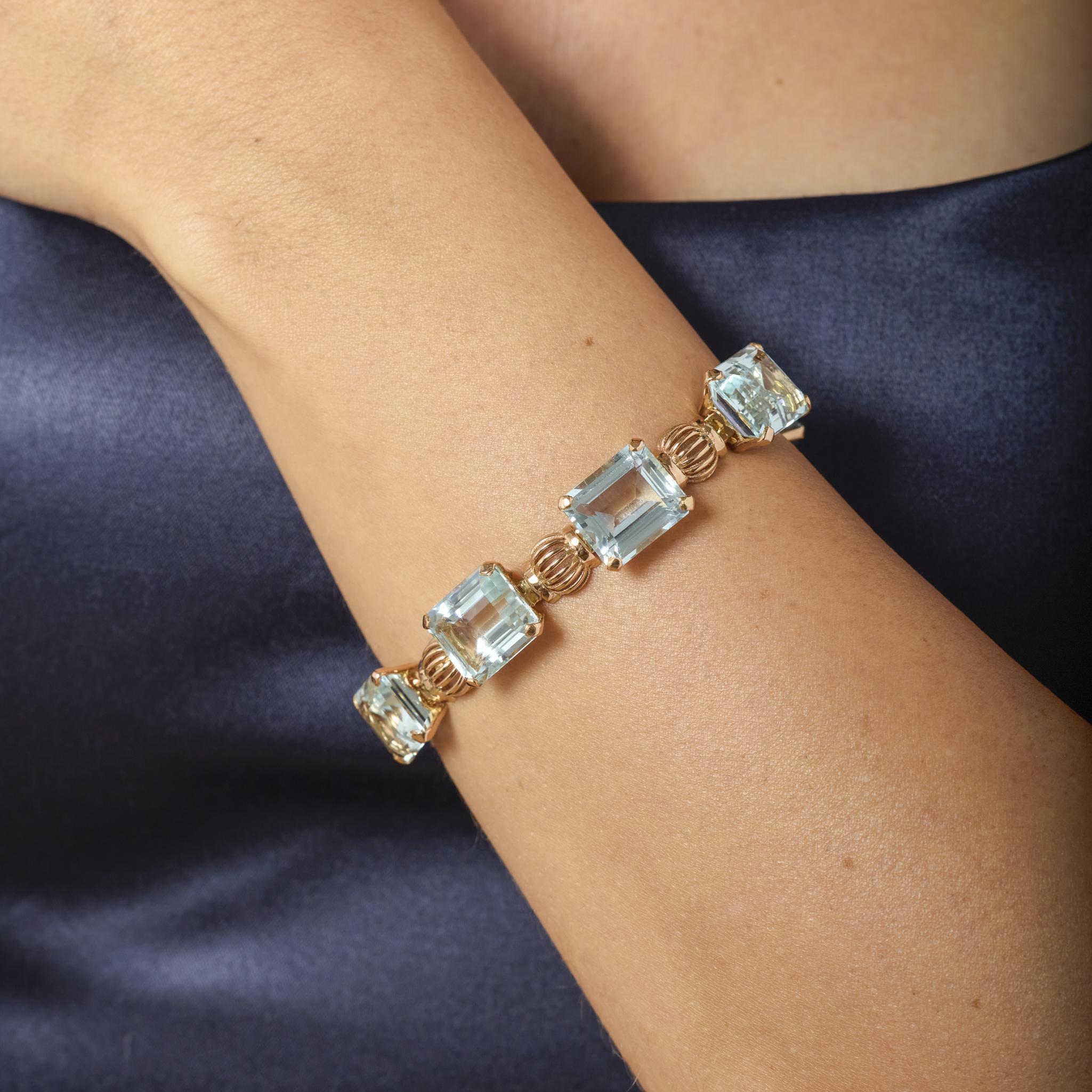Questo bracciale Retro in oro rosa 18 carati mette in mostra sette affascinanti acquamarine taglio smeraldo, che irradiano una morbida brillantezza blu in un design vintage audace ed elegante.