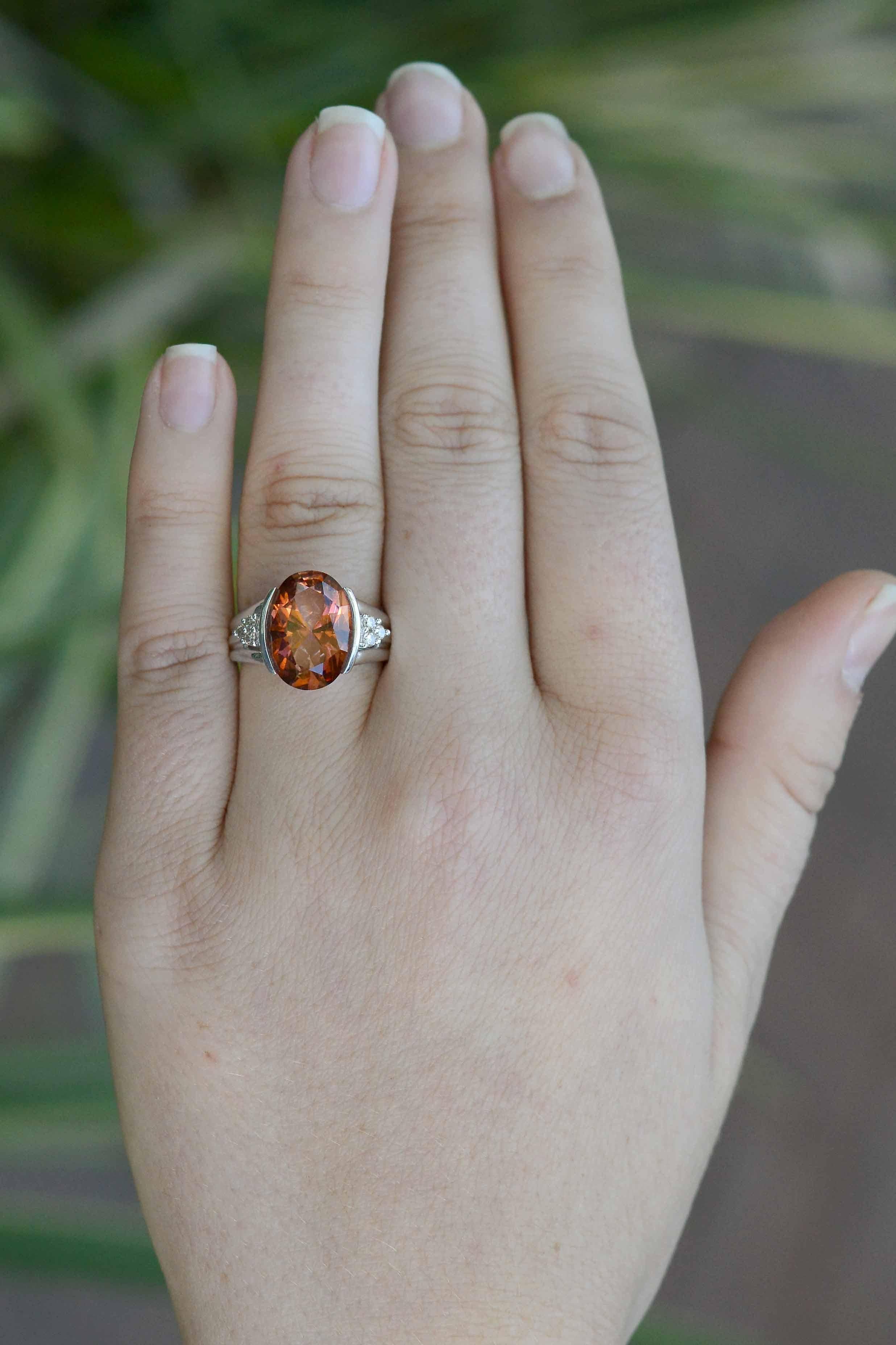 This energetic ring will reel you in with its ravishing pinkish orange tourmaline taking center stage. This intriguing peachy, Padparascha (Sanskrit for Lotus Flower) gemstone is hugged in a sleek 14k white gold basket affixed to 3 round diamonds on