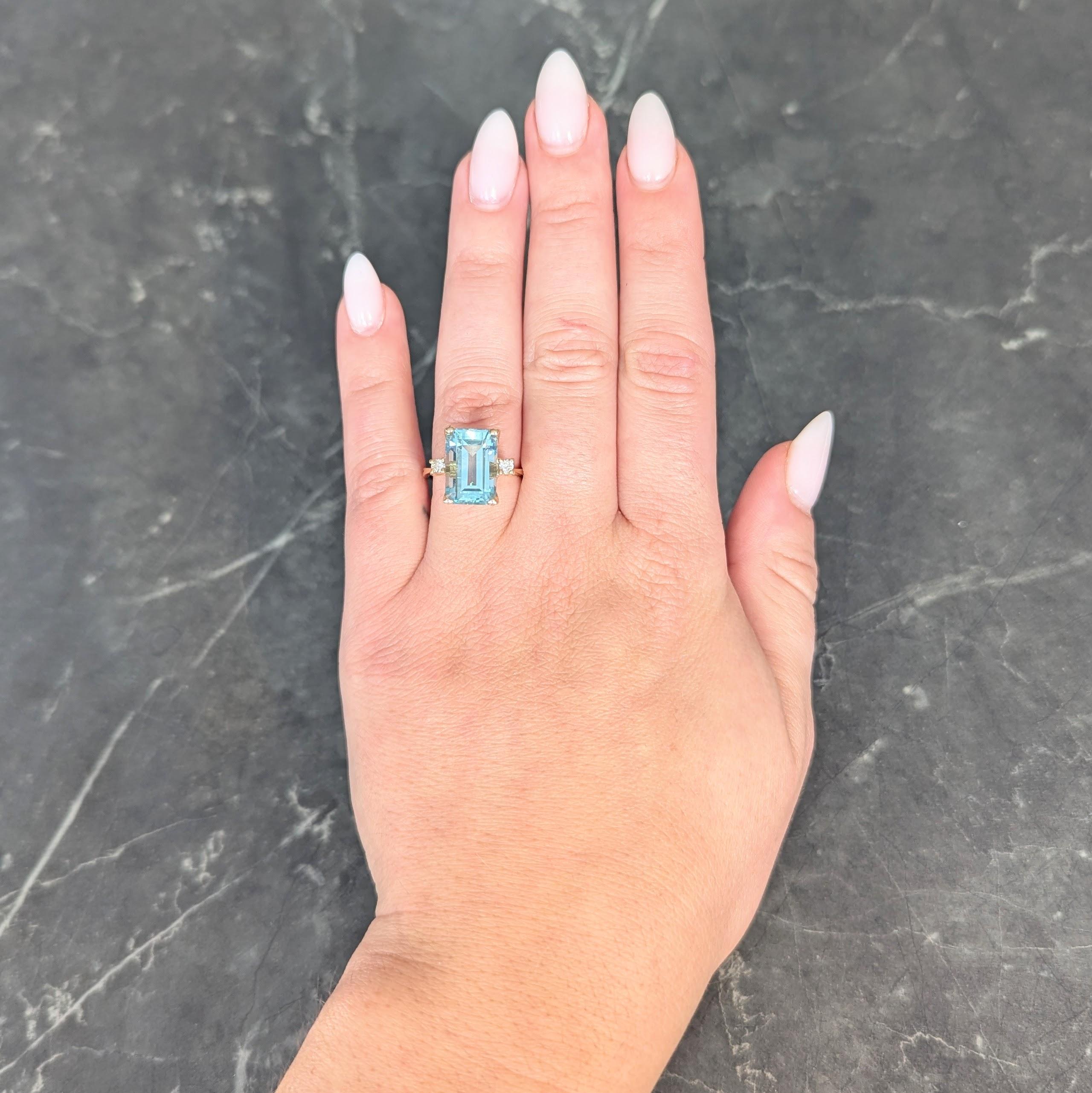 Centering an emerald cut aquamarine weighing approximately 6.45 carats
Transparent light blue in color and prong set in a pierced basket
Flanked by cathedral style shoulders prong set with diamonds
Round brilliant cut and weighing approximately 0.10