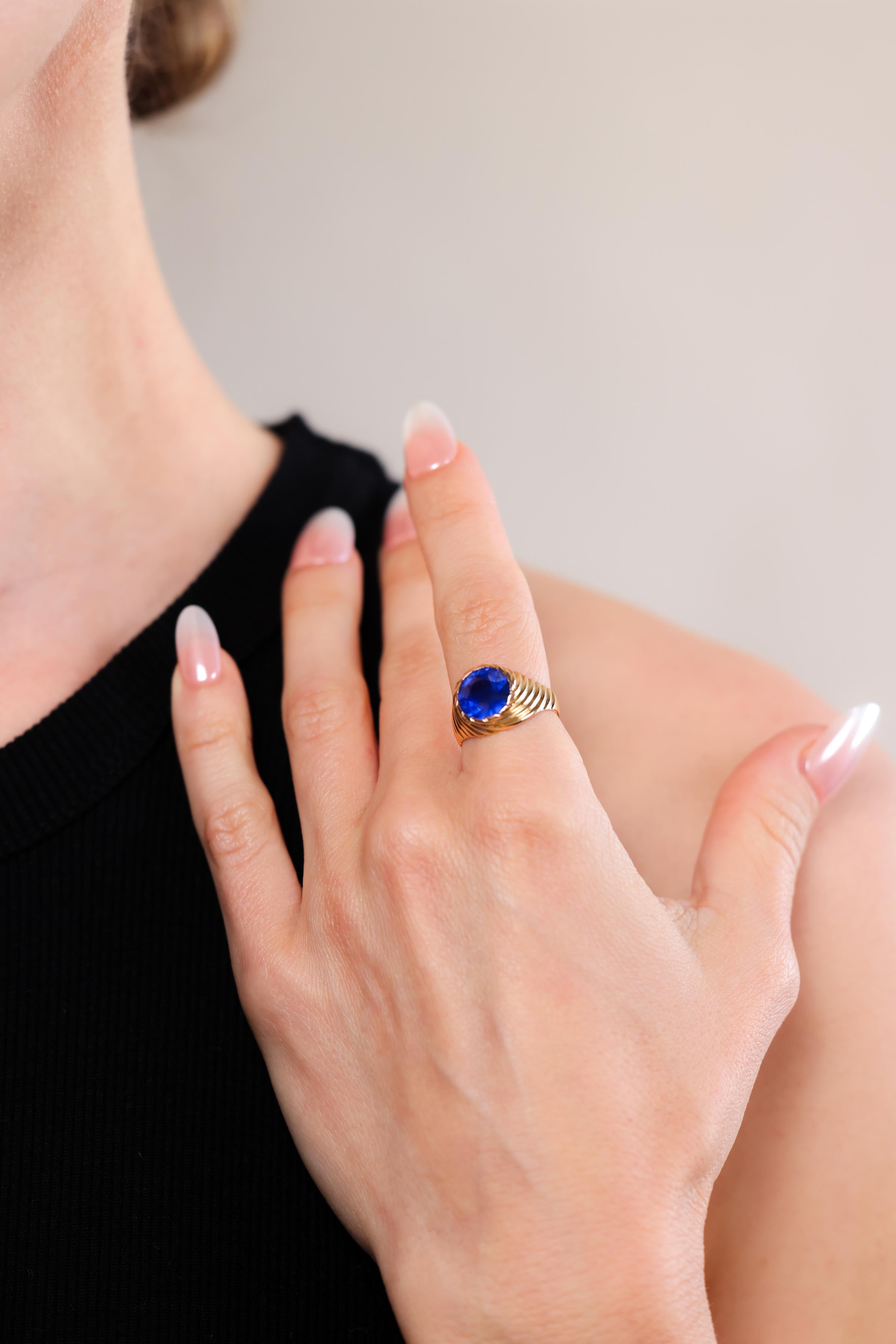 Certificate: AGL
Center Stone: Blue sapphire
Cut: Round
Weight: 4 carats approximately 
Metal: Fluted 18k yellow gold
Era: Retro
Circa: 1940s
Hallmarks: Purity marks
Size: 6-1/4 and can be resized 
Gram weight: 7.6
 
This exquisite ring exudes