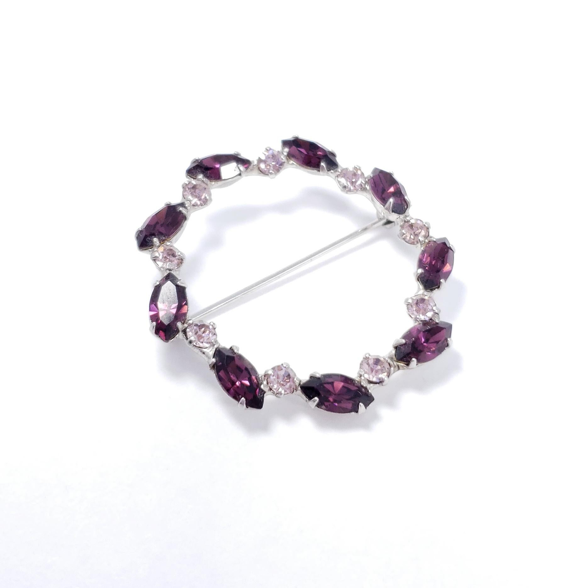 Pink and amethyst crystals prong-set in an open round silver-tone setting. A classy retro pin!

Circa mid 1900s.