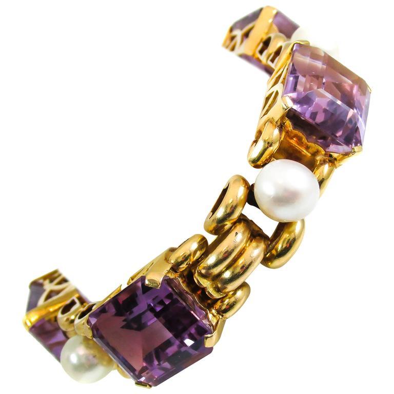 Alternating lavender purple emerald cut amethyst and smooth white cultured pearls are set in 18 karat yellow gold and spaced with polished yellow gold links. Beautifully hand-crafted and designed in the 1940s this flexible link bracelet is a bold