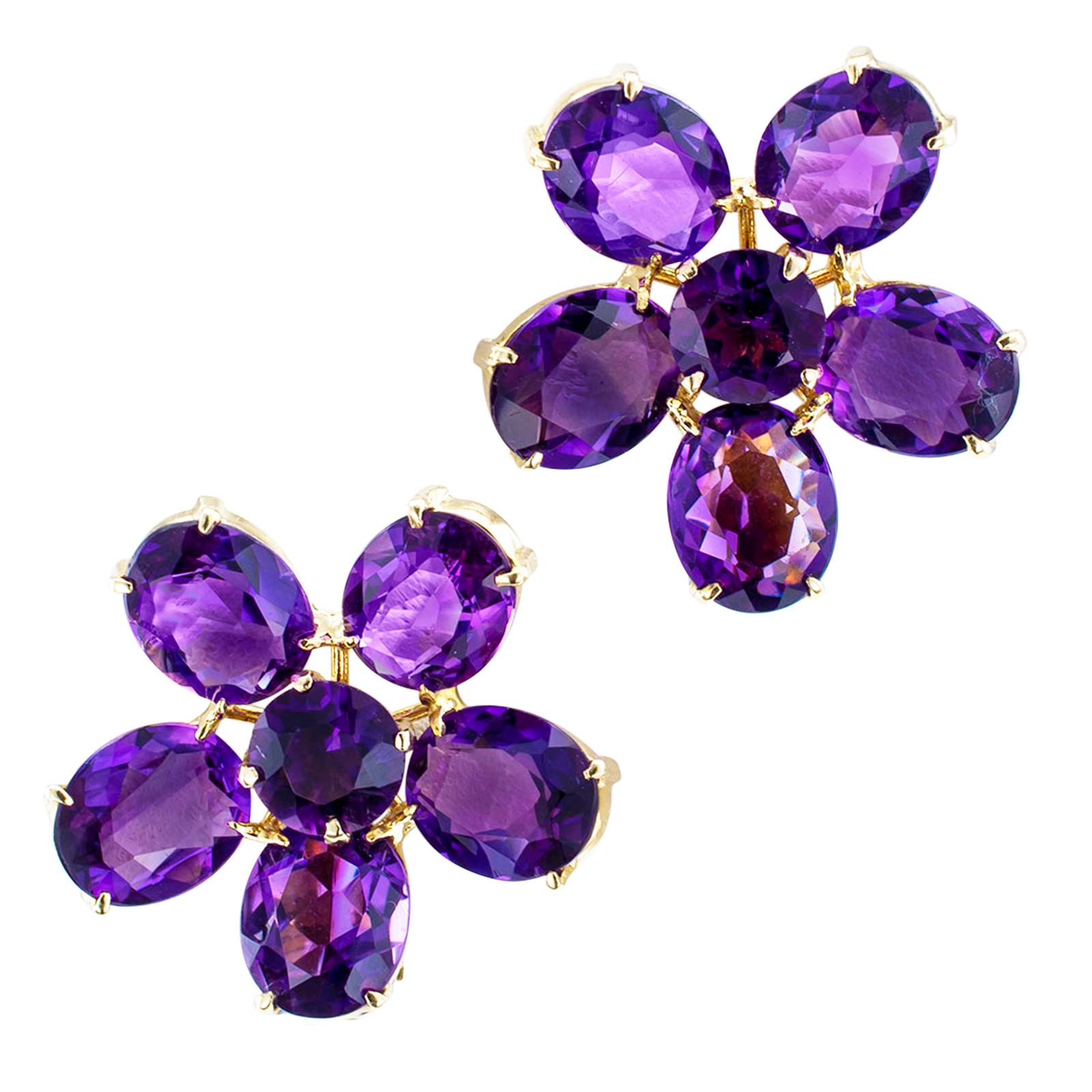 Retro amethyst and gold earrings.

DETAILS:
Retro flower-shaped amethyst and yellow gold clip back earrings circa 1950.
GEMSTONES: ten oval-shaped and two round faceted amethyst together totaling approximately 25.00 carats.
METAL: 14-karat yellow