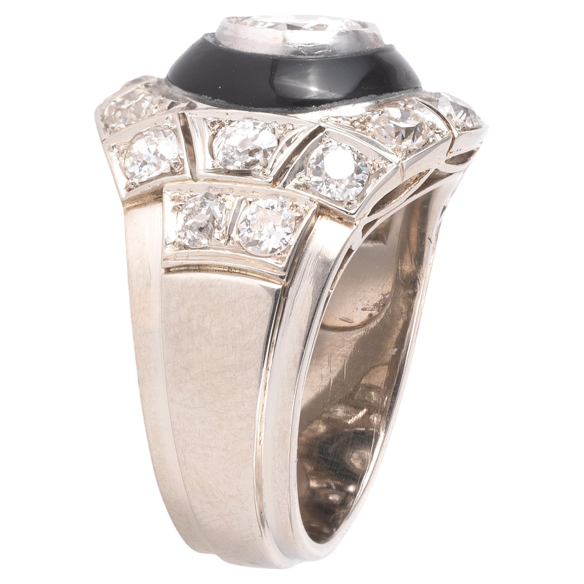 The carved onyx disc with an applied old brilliant-cut diamond, within a scalloped rubover setting, principal diamond approx. 1.8ct.

Period: 1950 ca.

Provenance: Italy.

Weight: 10.8 gr.

Finger size: 7 1/2