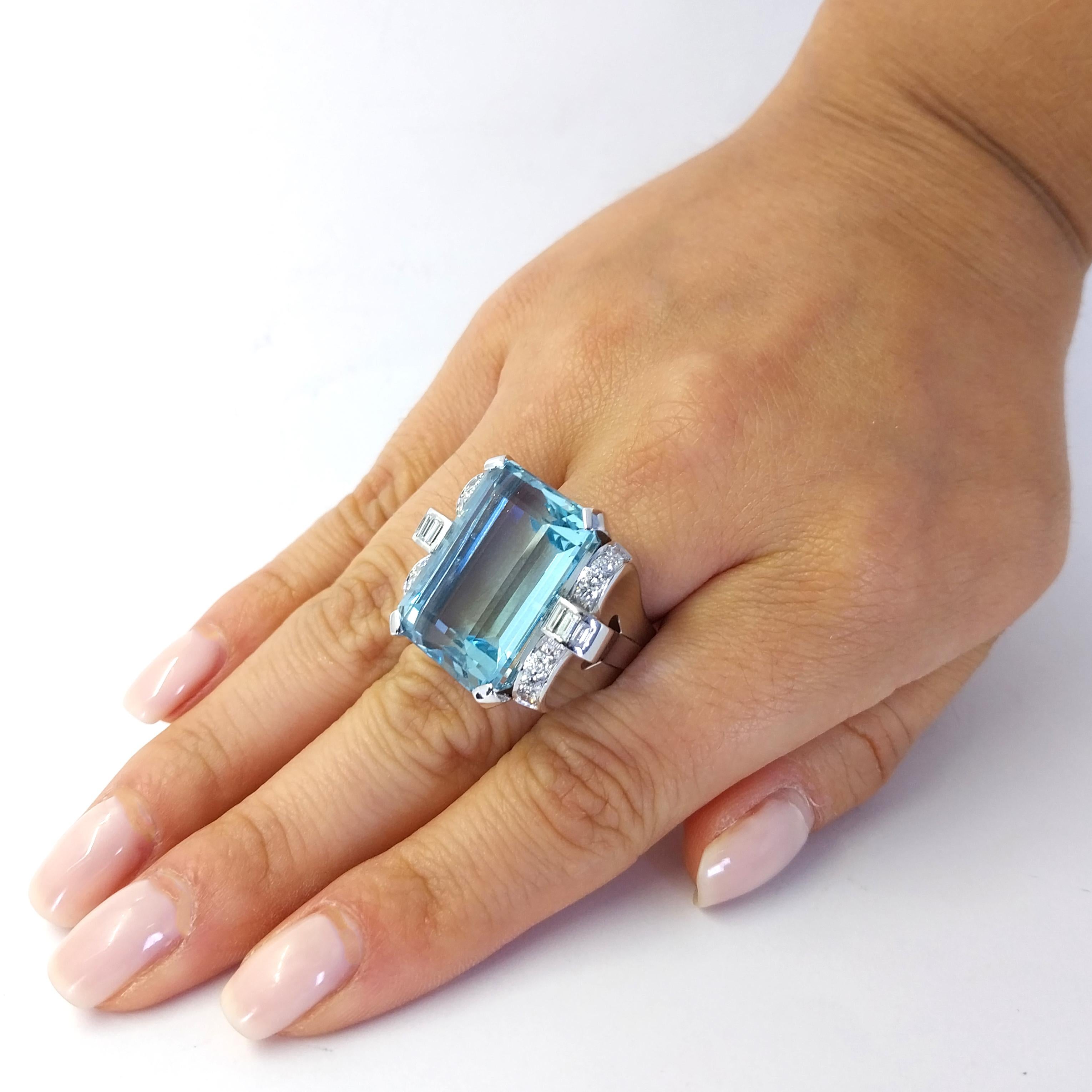 Enormous 18 Karat White Gold Retro Ring Featuring A 29.39 Carat Emerald Cut Aquamarine Accented by 18 Round and Baguette Cut Diamonds of VS Clarity and G Color Totaling 0.66 Carats. Finger Size 7.25. Purchase Includes One Sizing Service Prior to