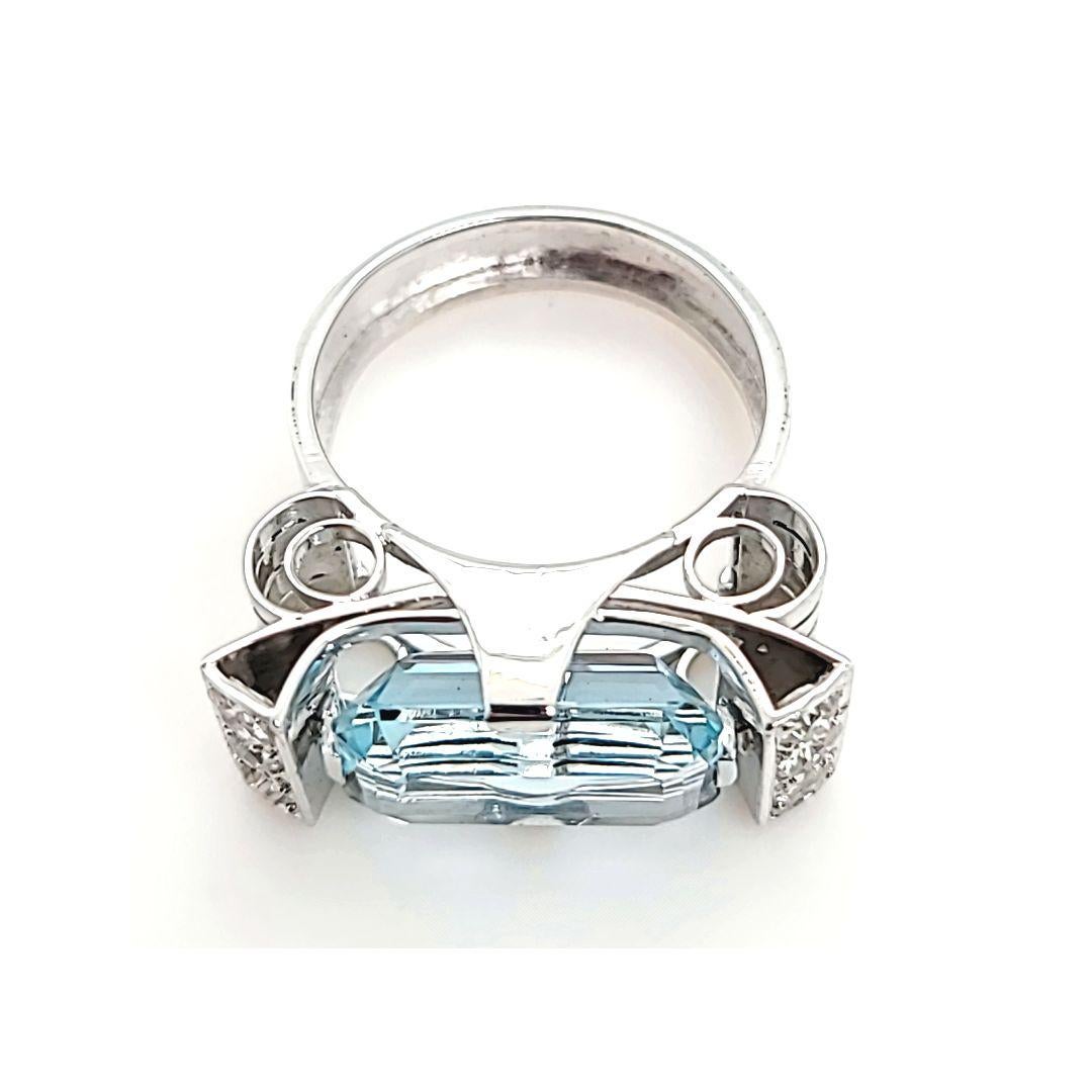 Platinum Cocktail Ring Featuring A 5.07 Carat Elongated Emerald Cut Aquamarine Accented by 6 Old Mine and Old European Cut Diamonds of SI Clarity and H Color Totaling 0.60 Carats. Finger Size 5.5. Purchase Includes One Sizing Service Upon Request.