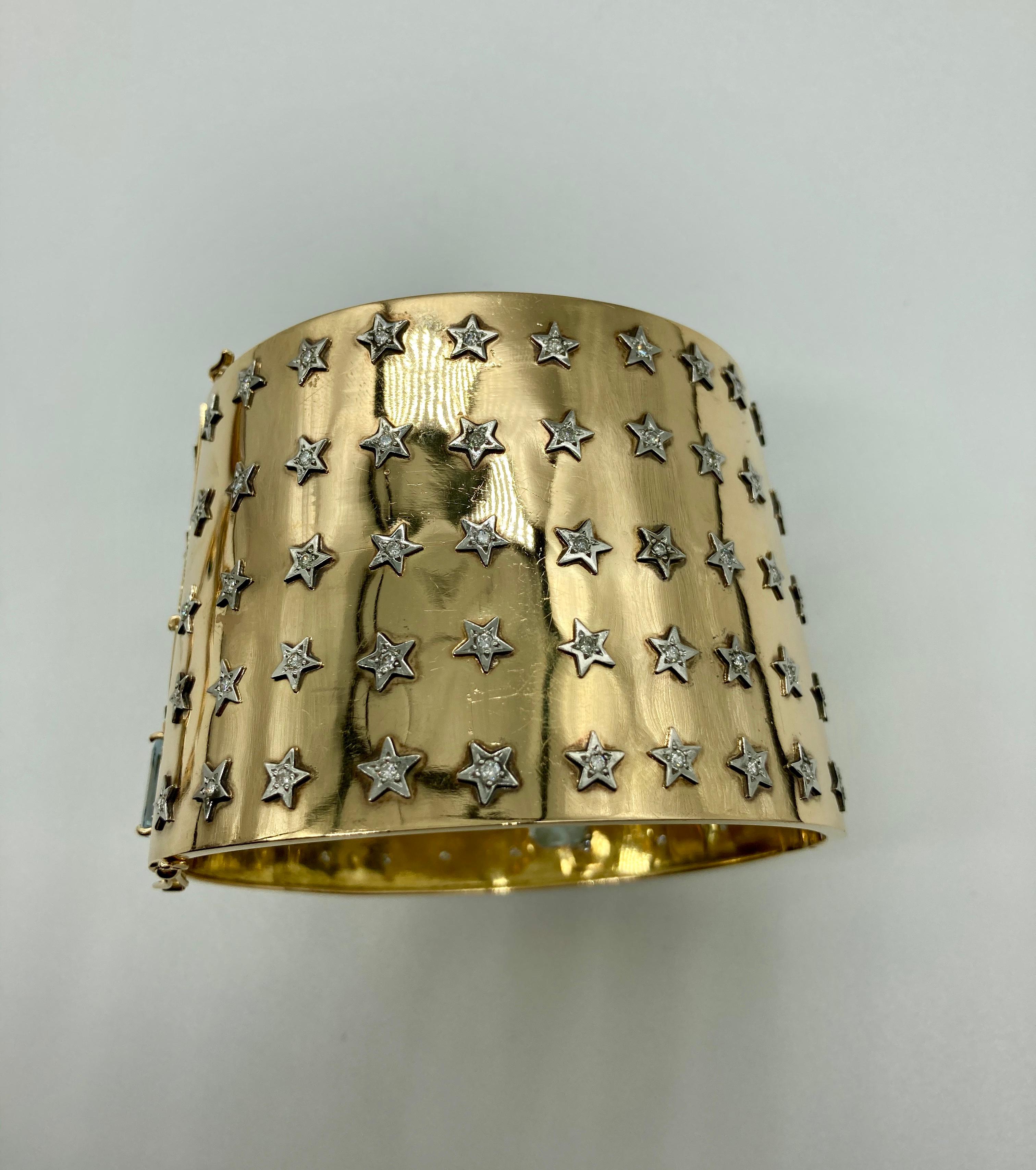 A retro 18 karat gold cuff bracelet embellished with diamond stars and accented with aquamarines. Circa 1940s, marked 750. Approximately 2.1 inches wide, inner circumference 8 inches.