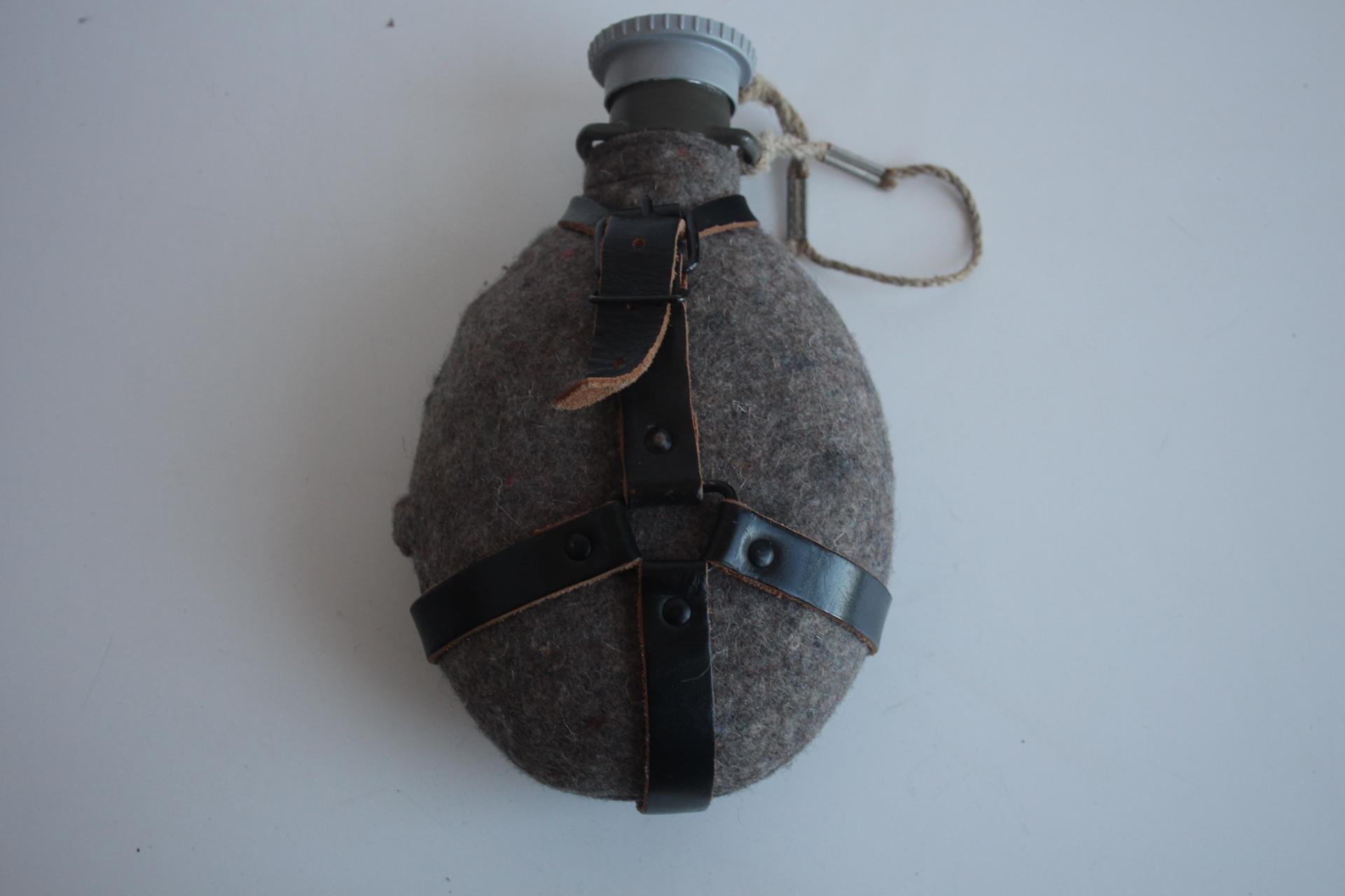 Pratica e leggera bottiglia da campo, volume di circa 0,75 l.
Realizzato in metallo, feltro, cintura in pelle, cappuccio in plastica
La custodia in feltro protegge la bottiglia da eventuali danni
Condizioni originali