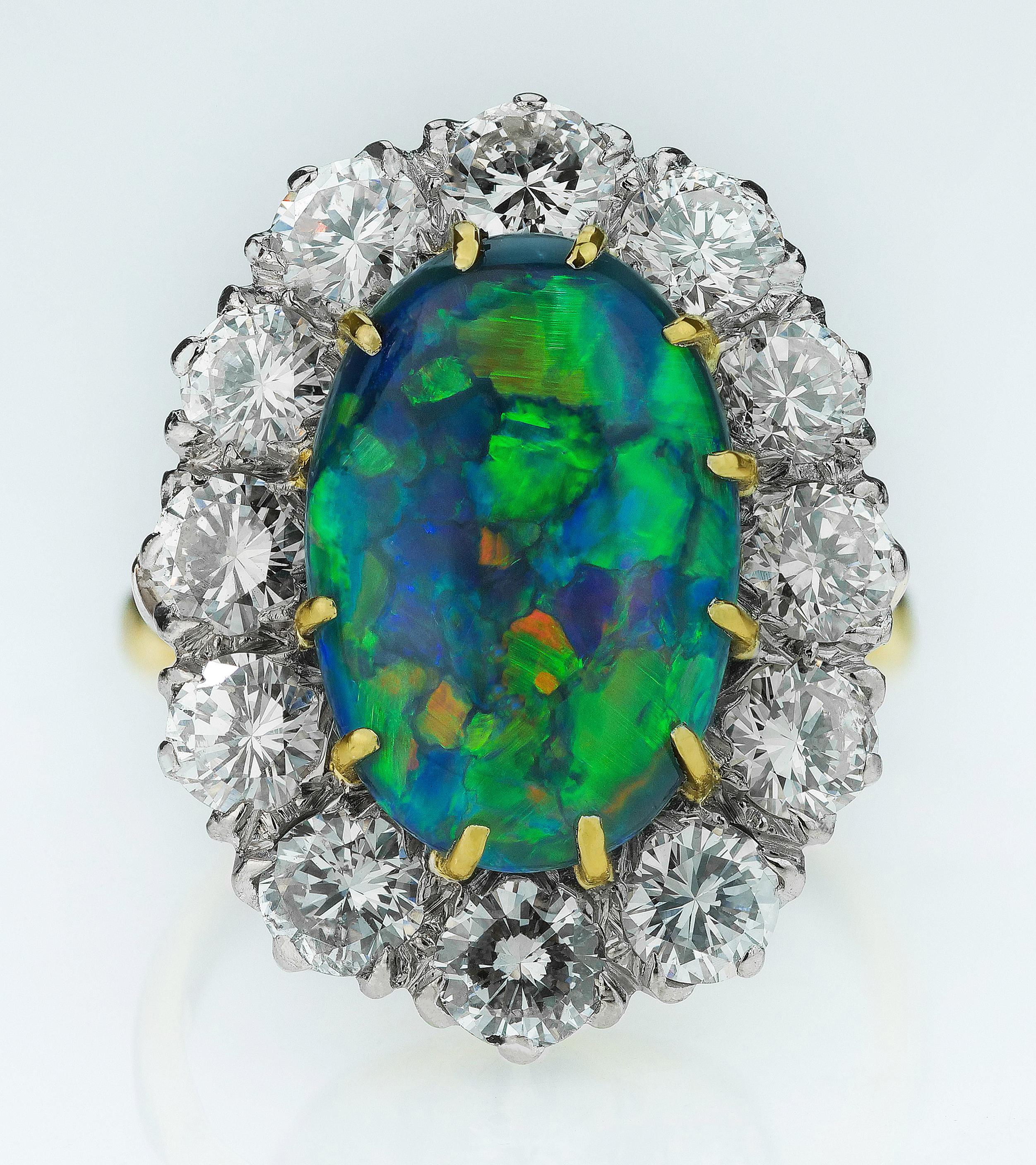 Australian black opal and diamond cluster ring in 18K white and yellow gold. Opal’s shifting play of kaleidoscopic colours is unlike any other gem. The Romans thought it was the most precious and powerful of all. 
1 x Cabochon black opal,