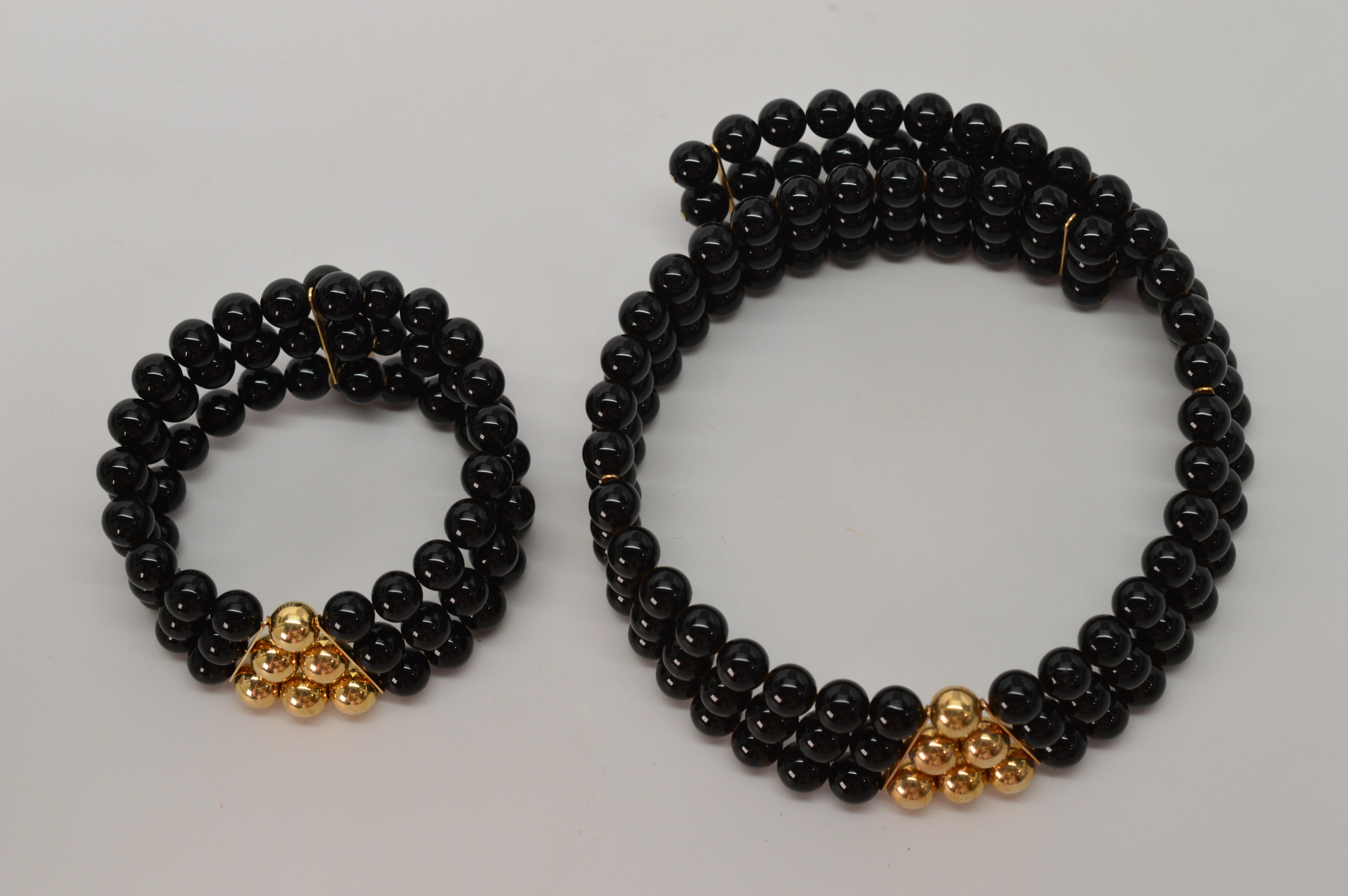 The striking combination of synthetic black onyx beads accented by a pyramid of vibrant 14K Gold beads create this fun on-trend retro trio.
Matching choker necklace, cuff bracelet and earrings can be worn together or separately, all new pieces from