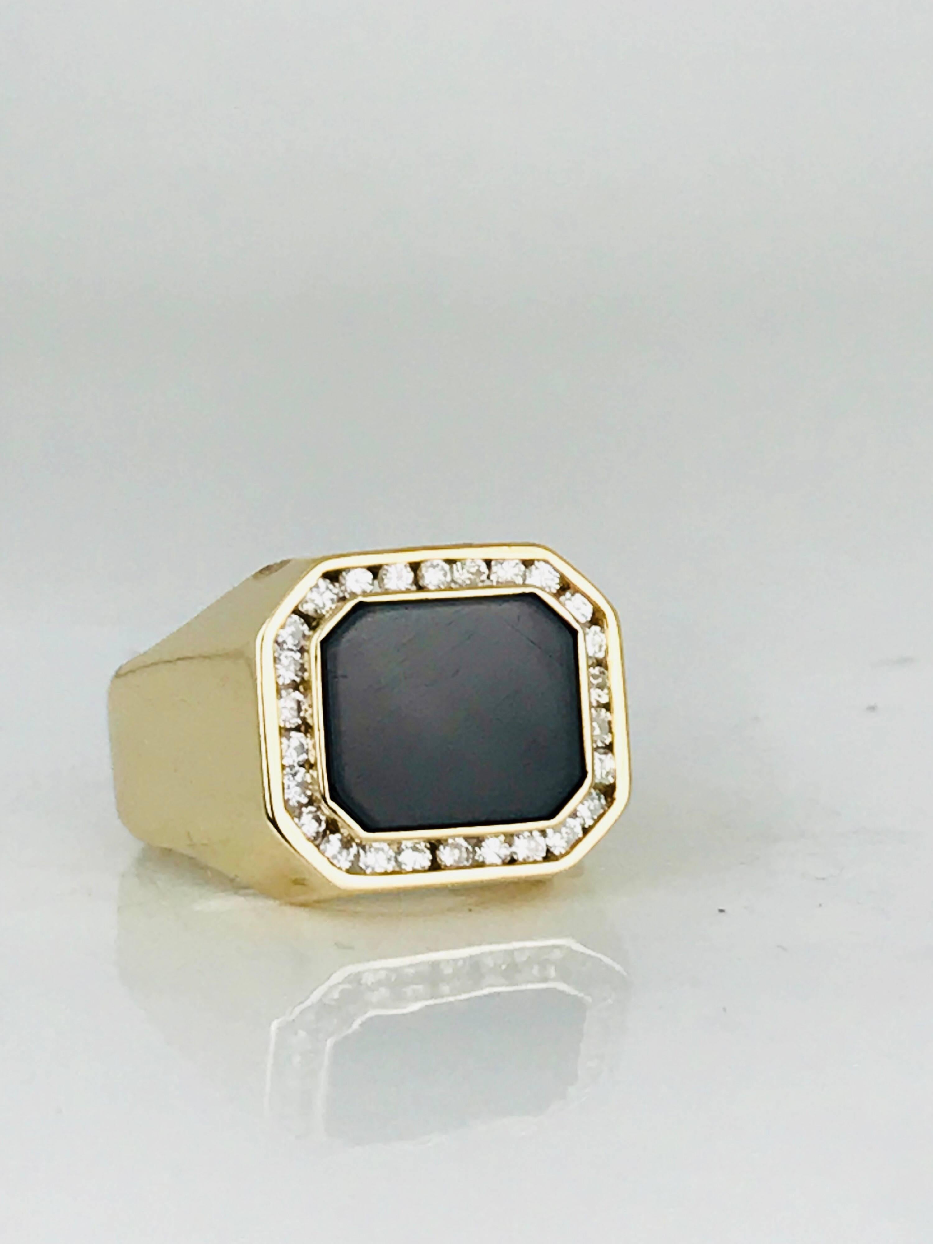 Retro Black Onyx, Channel-Set Diamonds, Yellow Gold Ring features a flat polished black onyx stone surrounded by round brilliant channel-set diamonds in 14 karat yellow gold.  The shape is a cut-corner rectangle.

26 round brilliant diamonds measure
