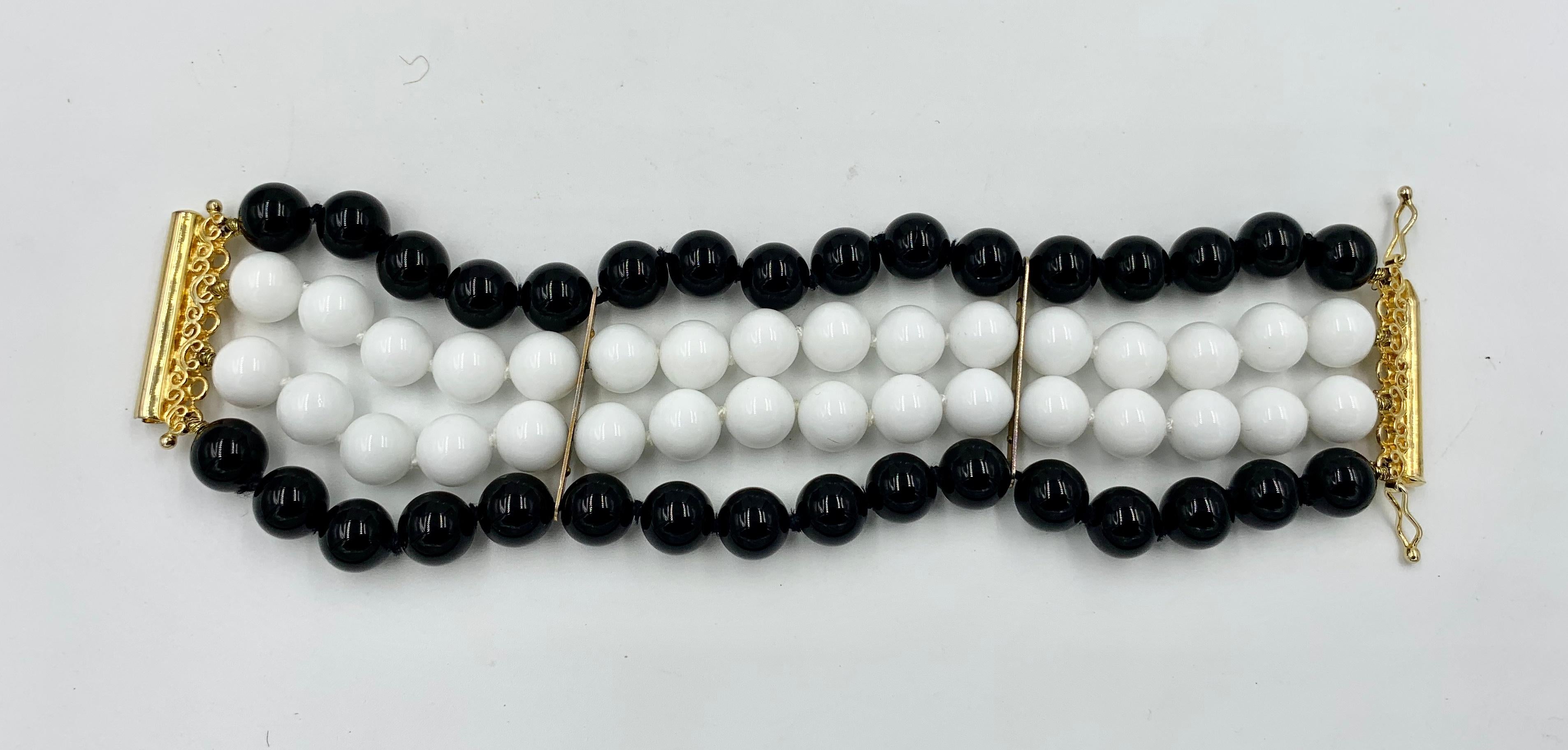 Un superbe bracelet à quatre brins de perles d'onyx noir et d'onyx blanc avec des perles d'onyx de 9 mm de large.  Le bracelet de déclaration dramatique avec les perles noires et blanches est tout simplement fabuleux.  Le bracelet mesure 6 pouces de