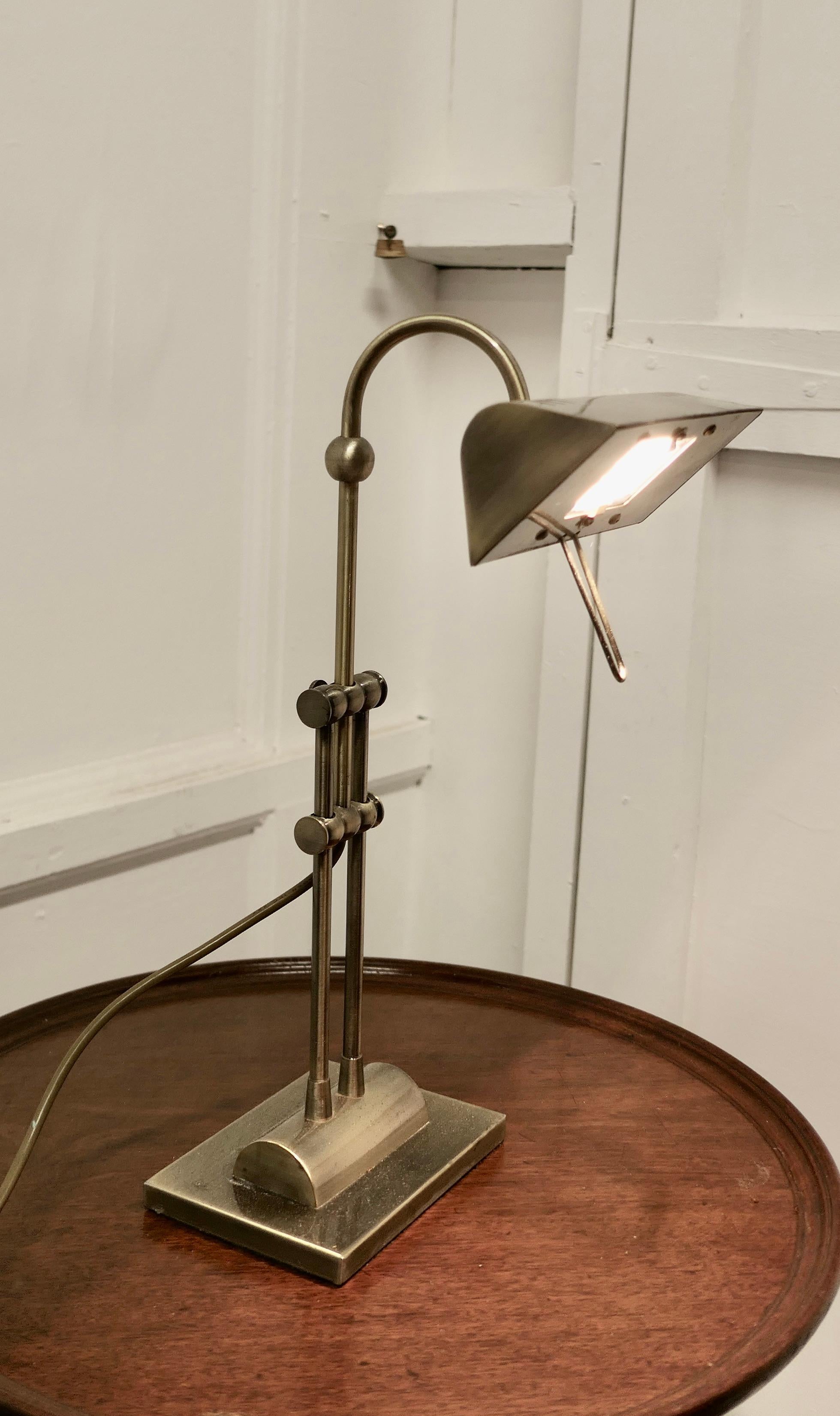 Retro brass adjustable bankers’s desk lamp. 

This is an attractive piece, the lamp is heavy, it has a rectangular brass base which supports the supporting arm, this alters the angle and height of the lamp.
The lamp has recent wiring and is fully