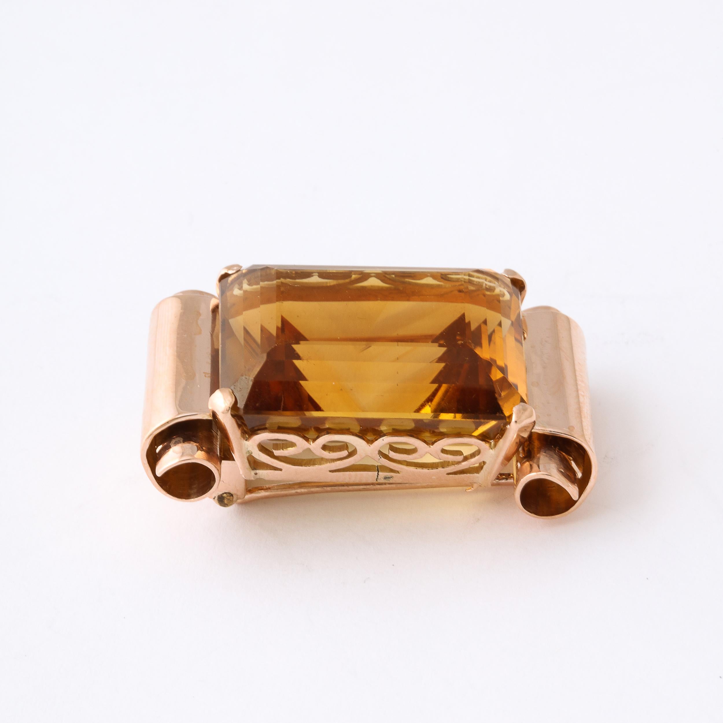 This Bold and glamorous brooch features a 40 carat emerald cut citrine set in a 18k rose gold scrolling mount. It is fitted for a brooch and also a chain can be looped through to make it a pendant.  This Brooch is very 1940s Hollywood at its best.