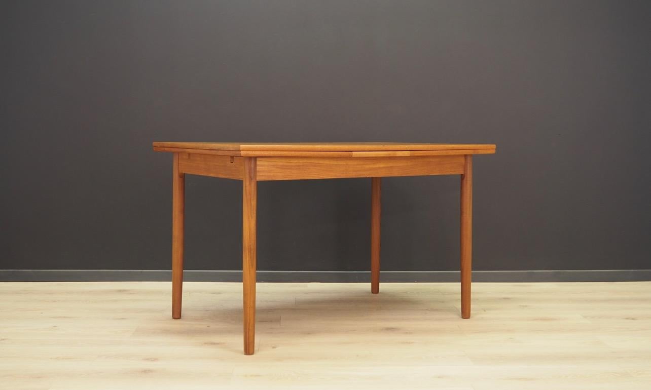 Fantastic Danish table from the 1960s-1970s, Minimalist form. Tabletop veneered with teak, legs made of solid teak. The table has two pull-out inserts. Preserved in good condition (small bruises and scratches) - directly for use.
 
Dimensions: