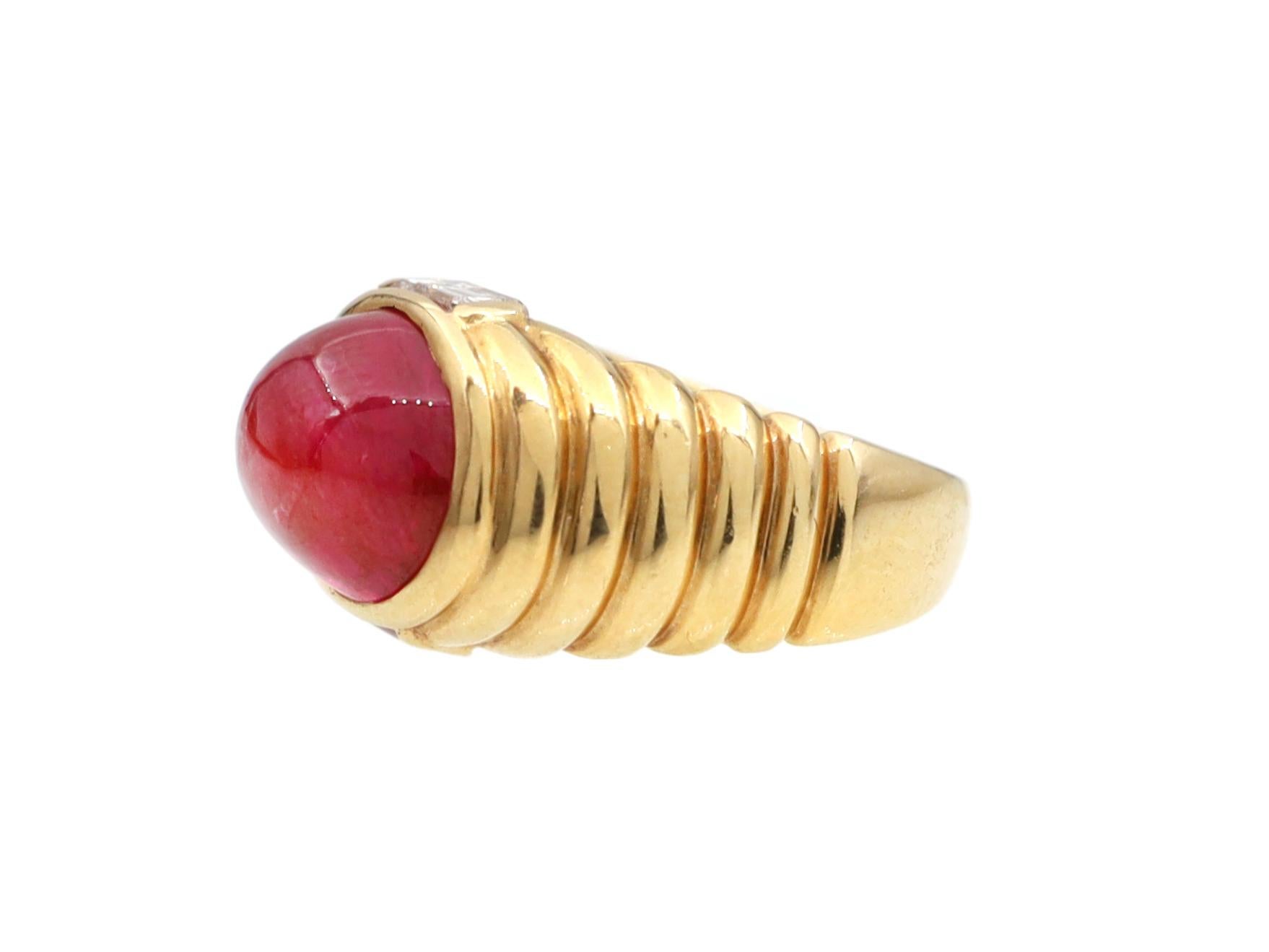Vintage Bulgari natural Burmese cabochon and diamond bombe ring in 18kt yellow gold. Centred with an oval cabochon Burmese ruby with no indications of heat treatment in a rubover setting, set to top and bottom inner with rectangular baguette cut