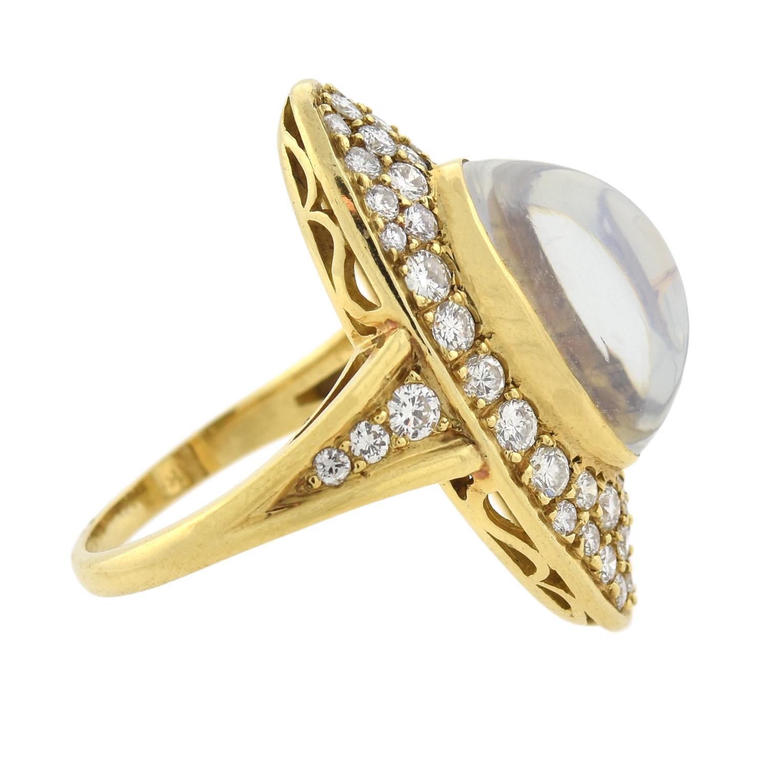 This outstanding moonstone ring from the late Retro (ca1950s) era is absolutely exquisite! Crated in vibrant 18kt yellow gold, the ring has an elongated oval shape which features a large cabochon moonstone in the center. The moonstone is bezel set,