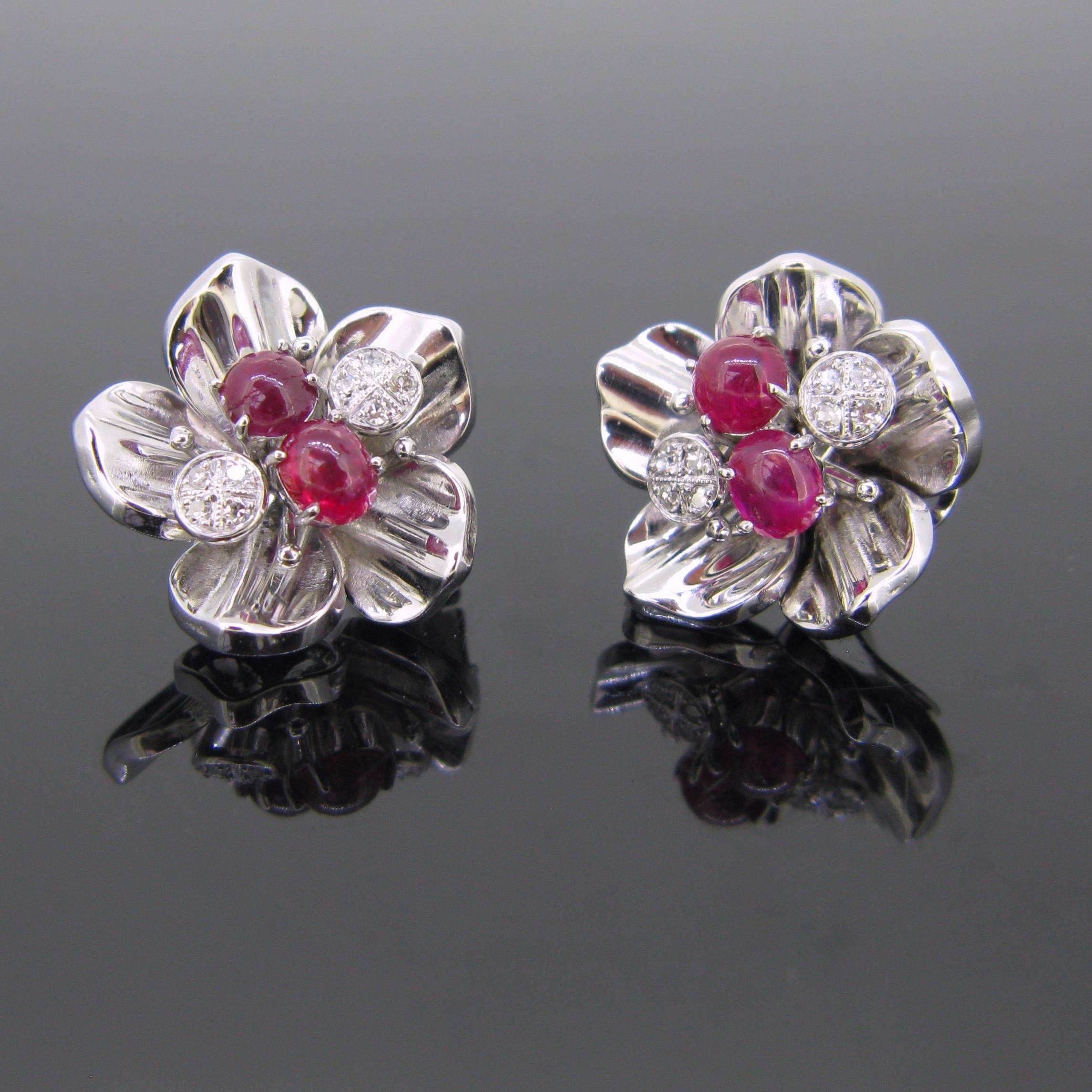 A beautiful pair of earrings clips. These have a flowery design. The center is adorned with 2 cabochon cut rubies.  They weigh around 0,90ct and 1ct. The 2 others pistils are set with 4 diamonds. So there is an approximate total carat weight of