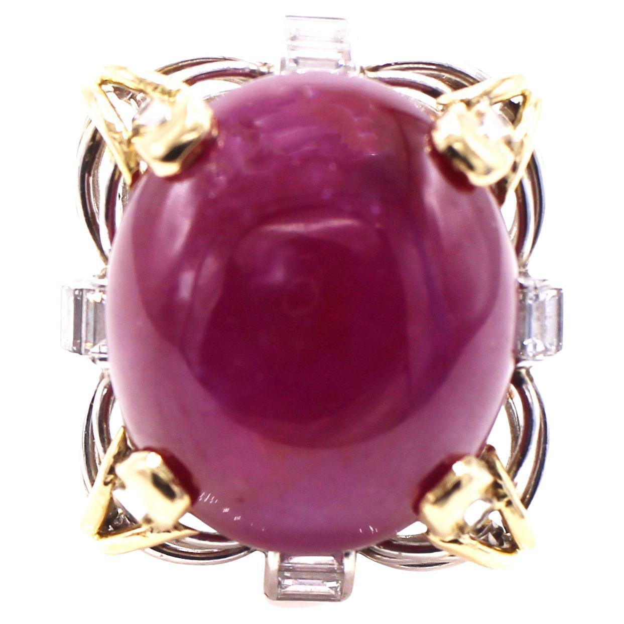 Beautifully designed and masterfully handcrafted Retro ruby and diamond ring from ca 1945, crafted in platinum and 18 karat yellow gold. The center piece of this ring is a large cabochon ruby weighing 34.68 carats held by 4 yellow gold and platinum