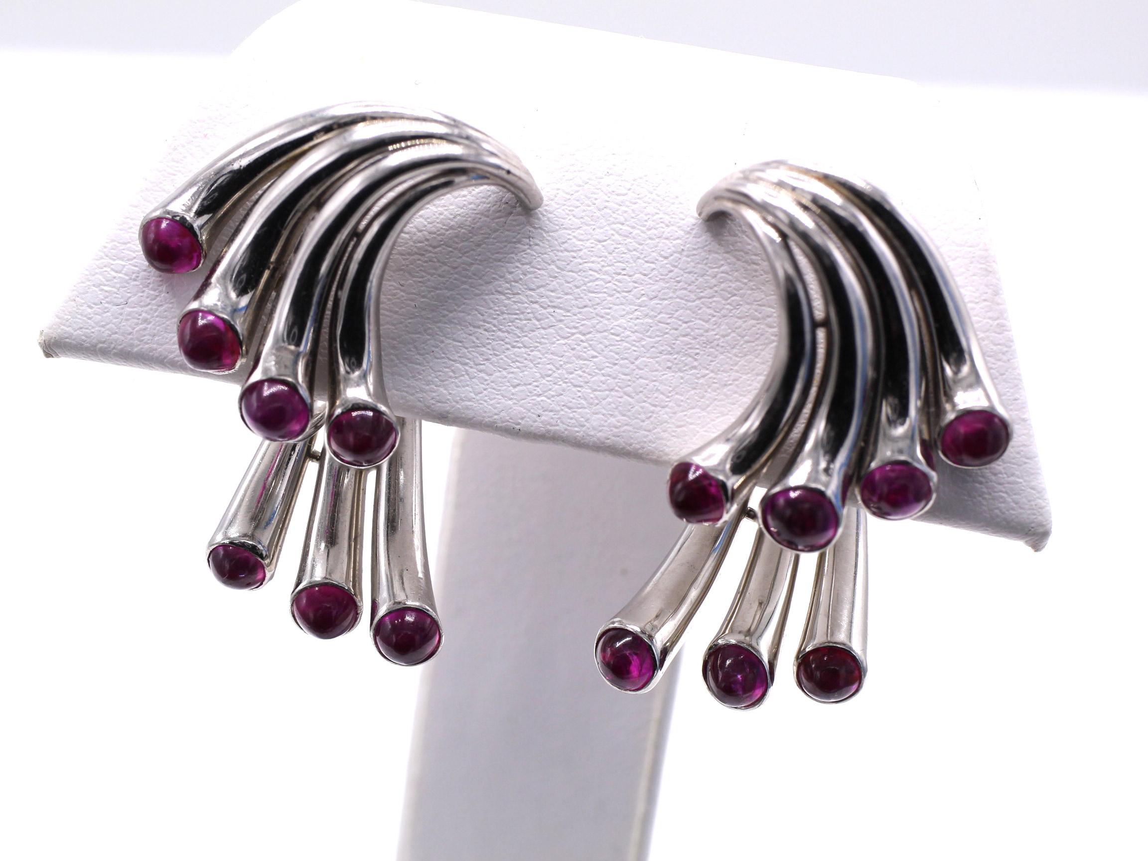 Amazingly designed and masterfully handcrafted in platinum, these unusual avant-garde ear clips are truly a piece of art on the ear. Curved platinum tubes curve outward, each set with a perfectly matched raspberry red cabochon ruby. The top is