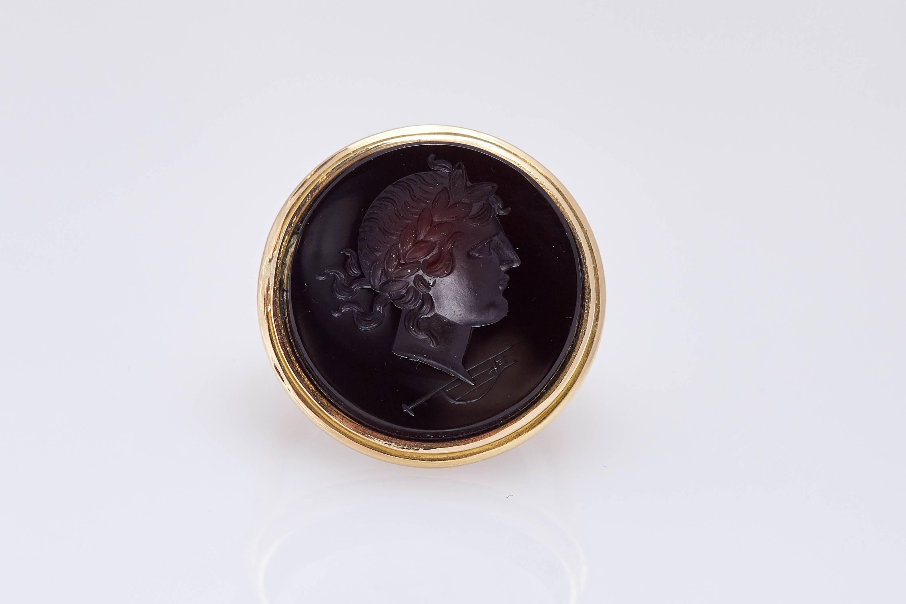An onyx cameo representing a female figure and musical instrument mounted on a fine 18kt yellow gold mounting. Made in Italy, circa 1950. 