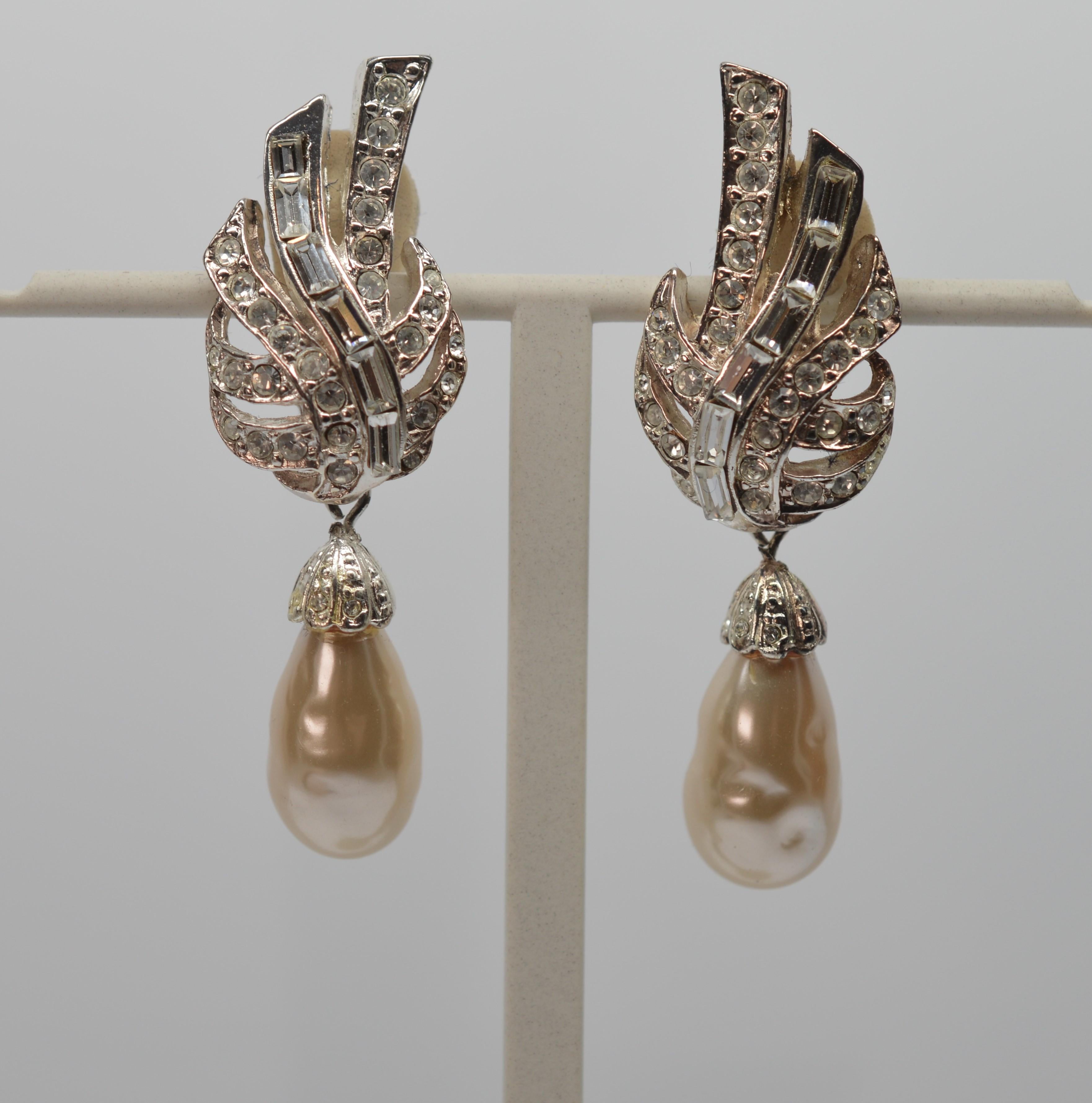 Over the top fun and dramatic, this retro earring pair is loud mid-nineties costume. Still with its original sales card, these are clip-on style earrings are of  cast silvertone metal with flashy Rhinestones and imitation Pearls Drops.  Measuring