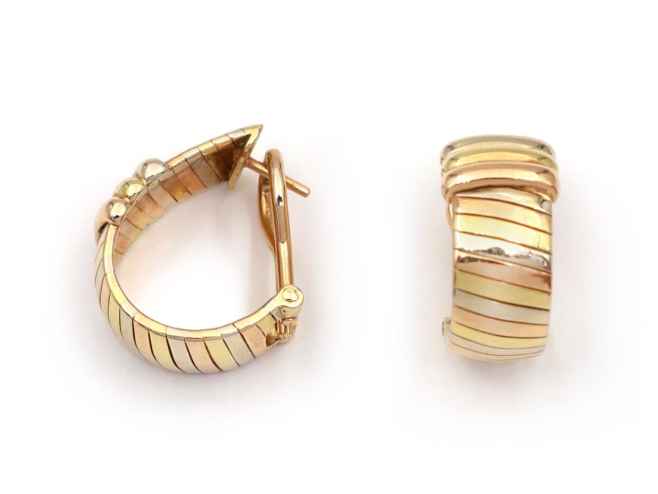 Retro Cartier tubogas 18kt tri-gold hoop earrings. A matching pair, each consisting of a gaspipe link in alternating white, rose and yellow gold with a raised ribbed central terminal, fitted to the reverse with a secure post and hinged omega clip.
