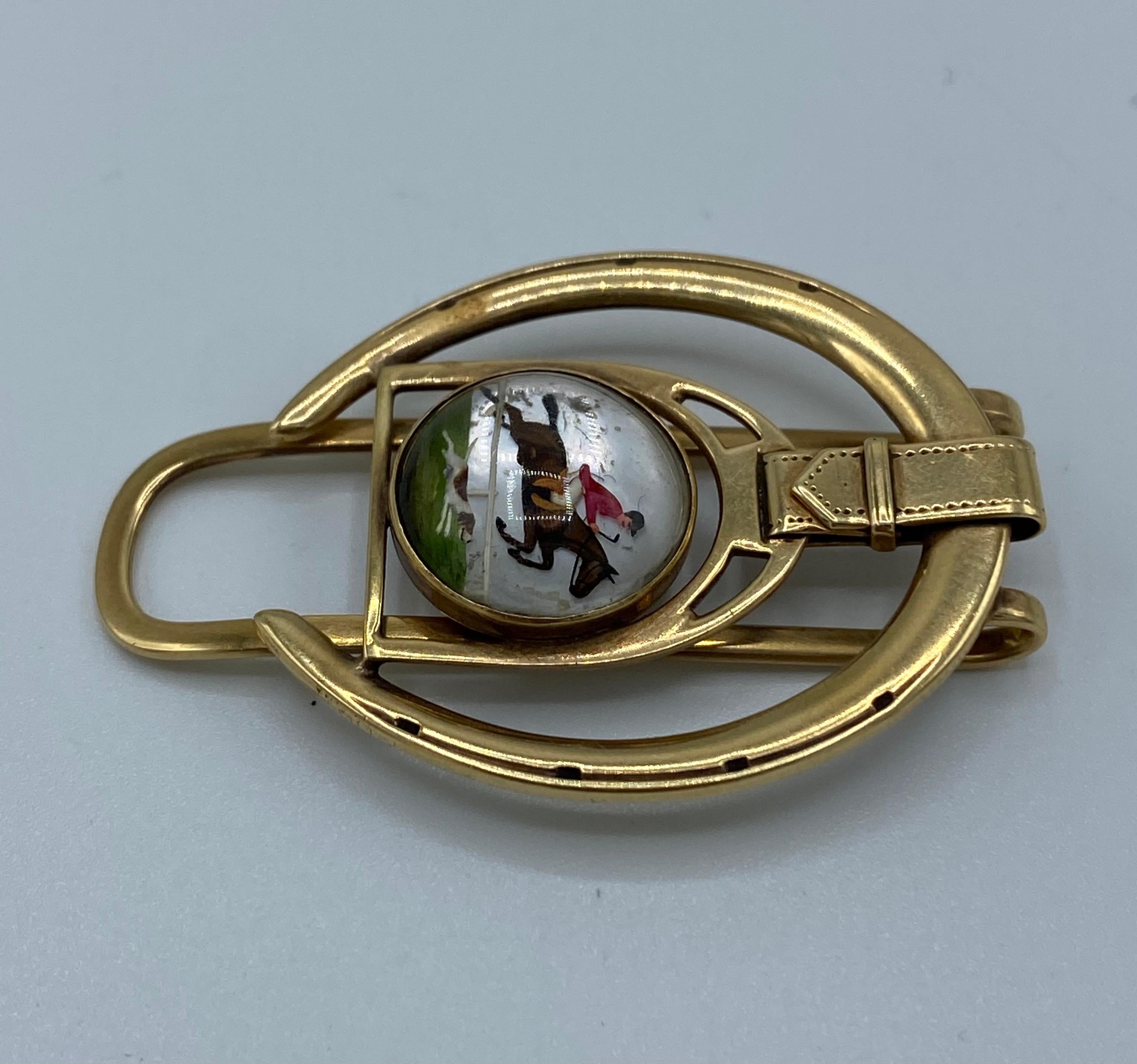 Product details:

The money clip is designed by Cartier in the 1940's. It is made out of 14 karat yellow gold, enamel cover with rock crystal over it. It features horseshoe and man on the horse, equestrian motif.