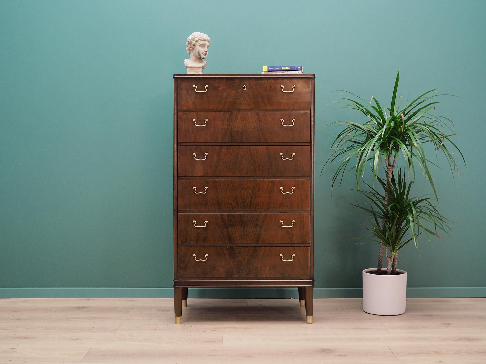 Superb chest of drawers from the 1960s-1970s. Danish design, Minimalist form. Surface of the furniture covered with walnut veneer, legs made of solid walnut wood. Chest of drawers has six spacious drawers, no key included. Preserved in good