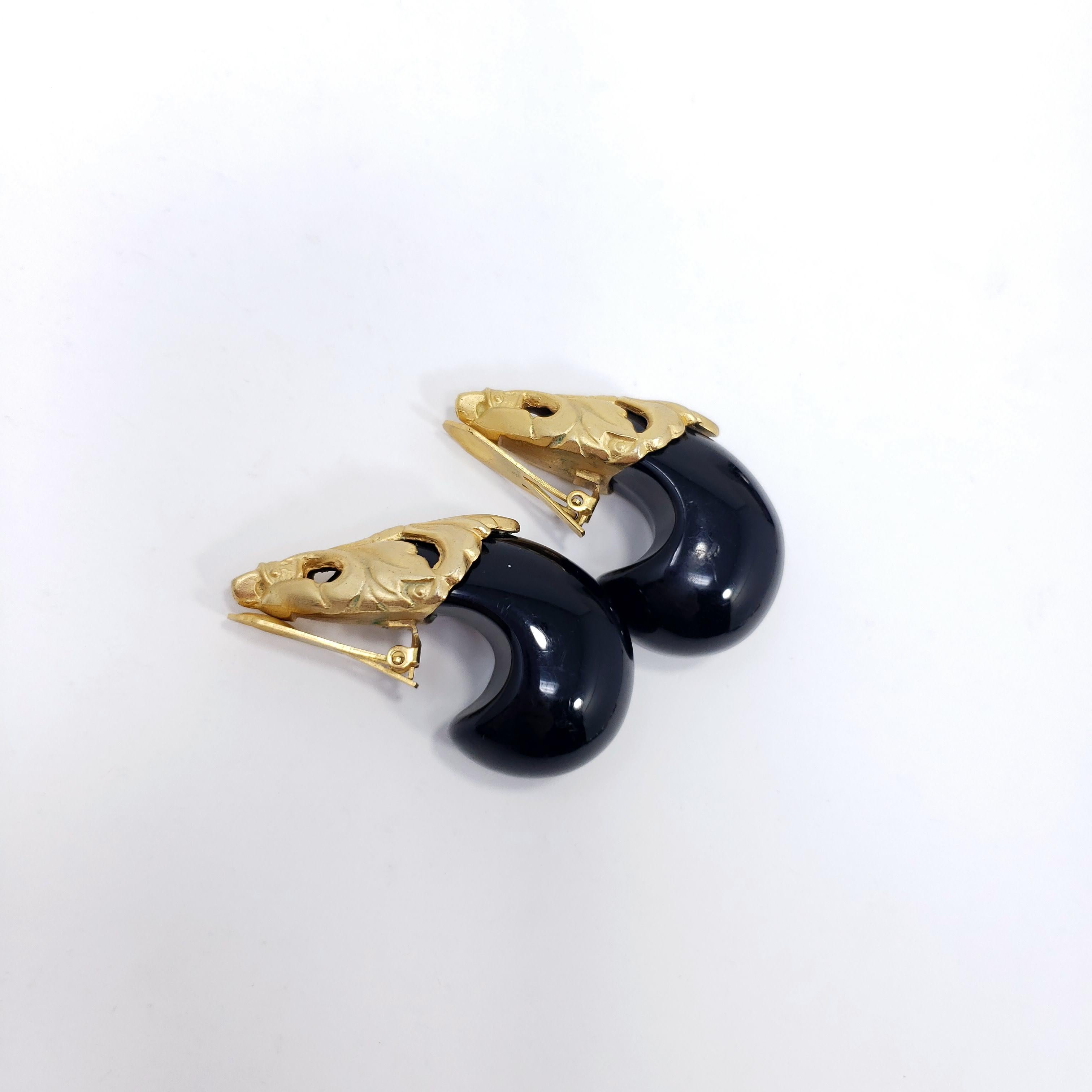 Retro-Schick! Diese großen und auffälligen Clip-Ohrringe haben klobige Harzakzente für einen stilvollen Look.

Gold-Ton.

Etwa Ende der 1900er Jahre.