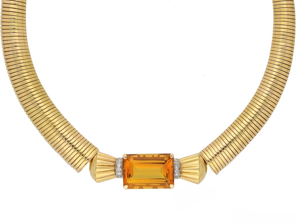 Retro citrine and diamond necklace, circa 1945. An 18ct yellow gold necklace set with one central rectangular emerald cut citrine in a claw setting with an approximate weight of 40.00 carats, above an openwork undulating gallery, flanked by vertical
