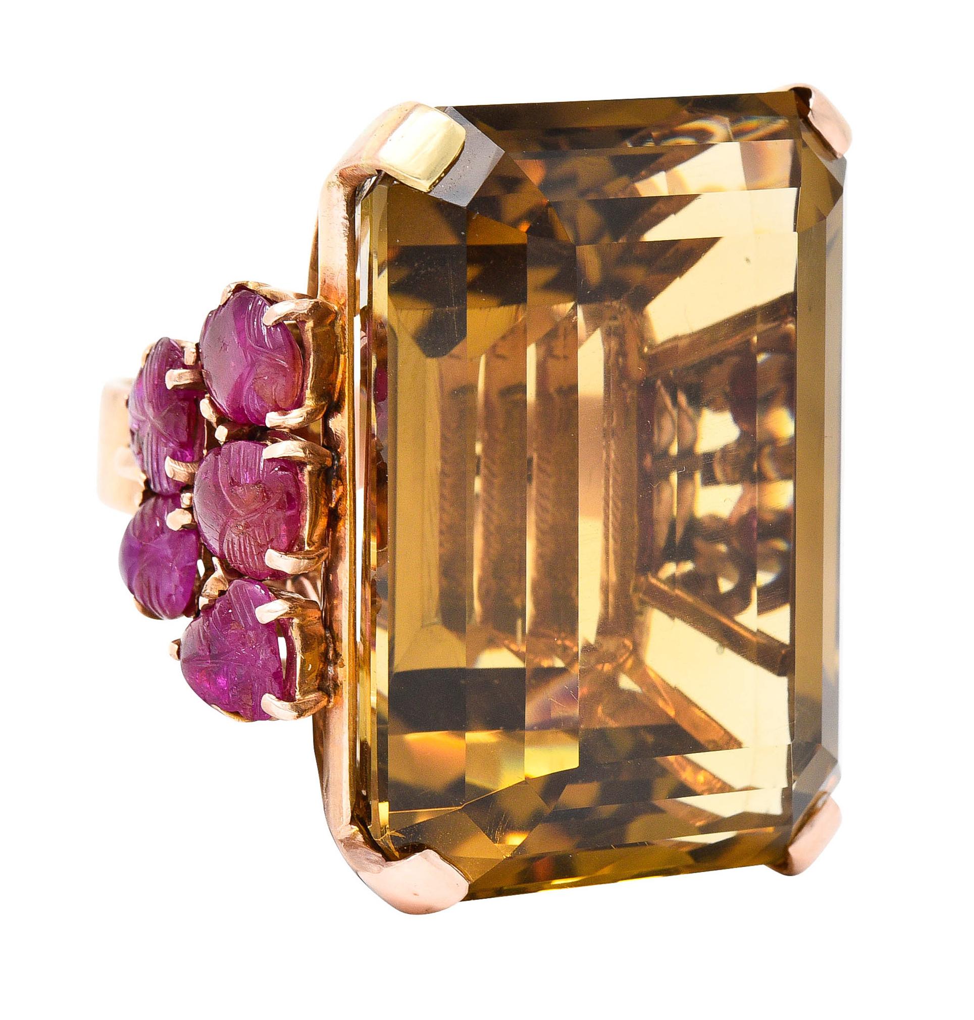 Featuring an emerald cut citrine measuring 34.0 x 24.8 mm

Basket set with strongly brownish orange color - eye clean

Flanked by stylized cathedral shoulders with scrolled volutes

Decorated with Mughal carved rubies depicting leaves

Rubies are