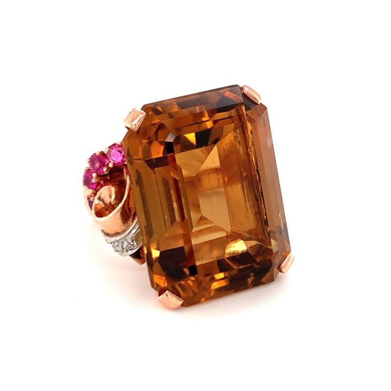 One Retro citrine, ruby and diamond 18K rose gold ring featuring 1 emerald cut, deep orangey-brown citrine weighing 52 ct. Enhanced by 8 round brilliant cut rubies totaling 0.70 ct. and 4 single round cut diamonds totaling 0.06 ct. Circa