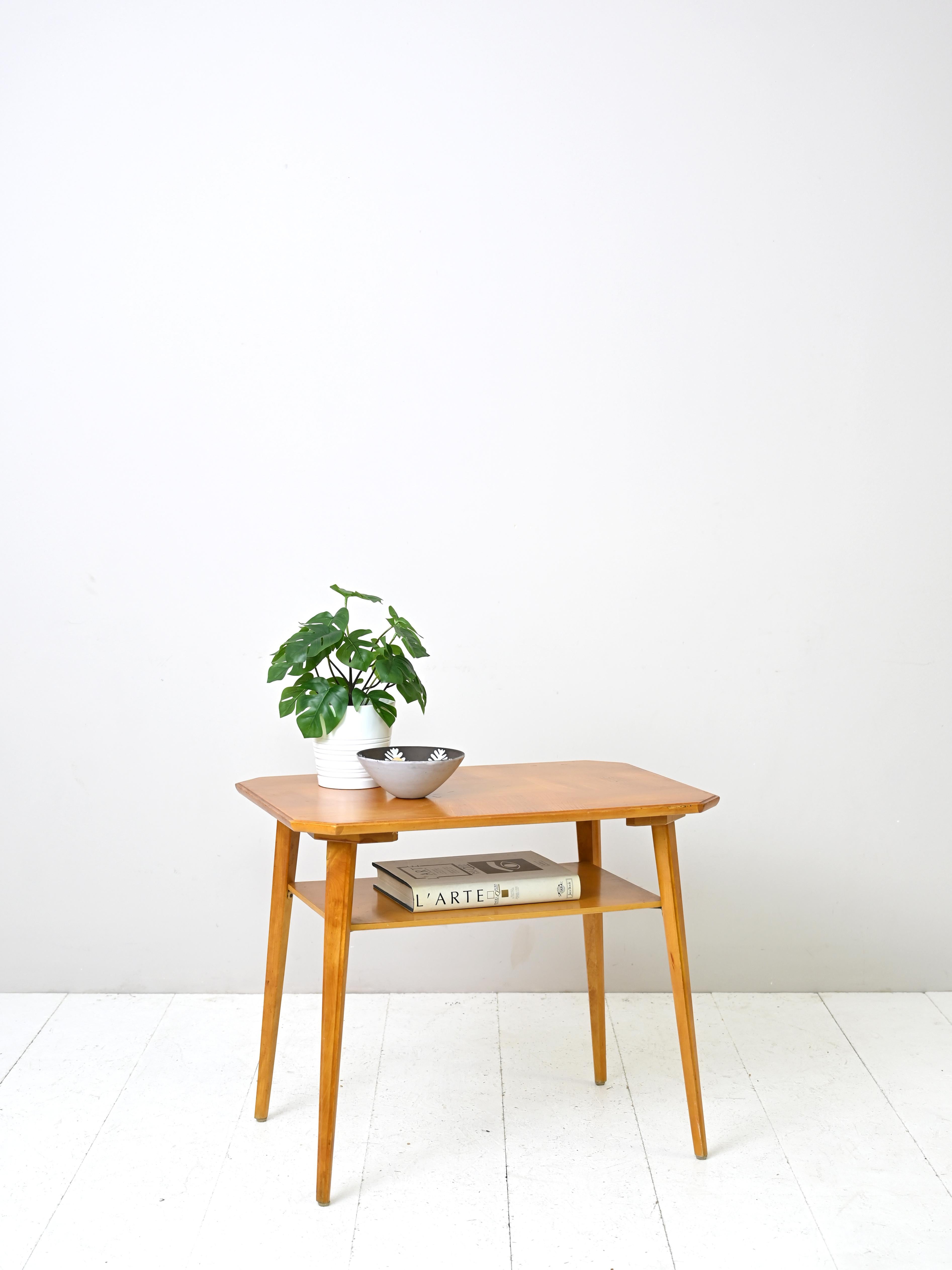 Original mid-century sofa table of Scandinavian provenance. 

The birch wood frame consists of a wide top and long tapered legs. There is also an elegant wooden magazine shelf.

Good condition. A conservative restoration has been done. It may