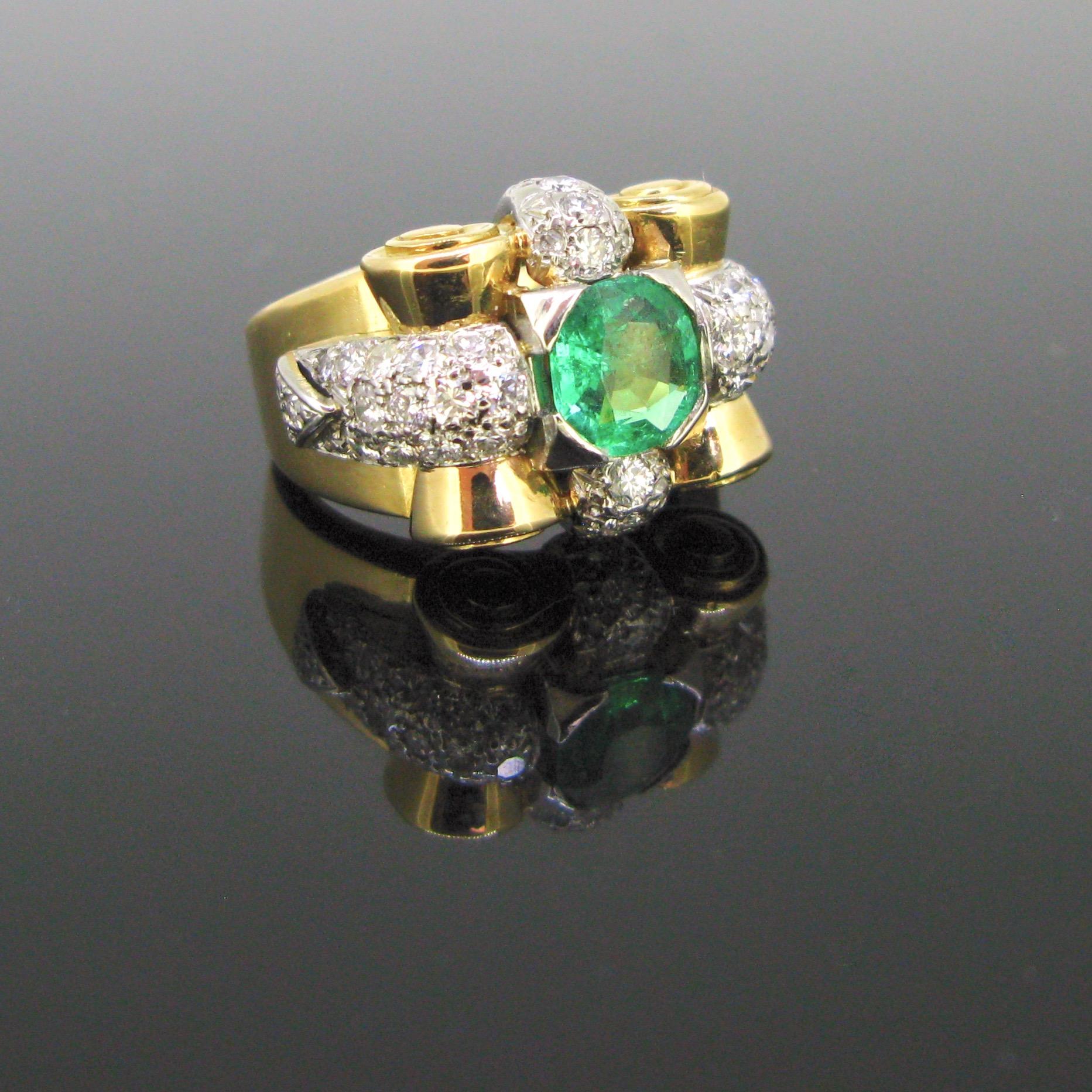 This ring has a beautiful geometric and bold design, characteristic of the Retro period. It is set with a vibrant green emerald from Colombia weighing around 1.10ct. The ring is adorned with brilliant and single cut diamonds, set on platinum. It has
