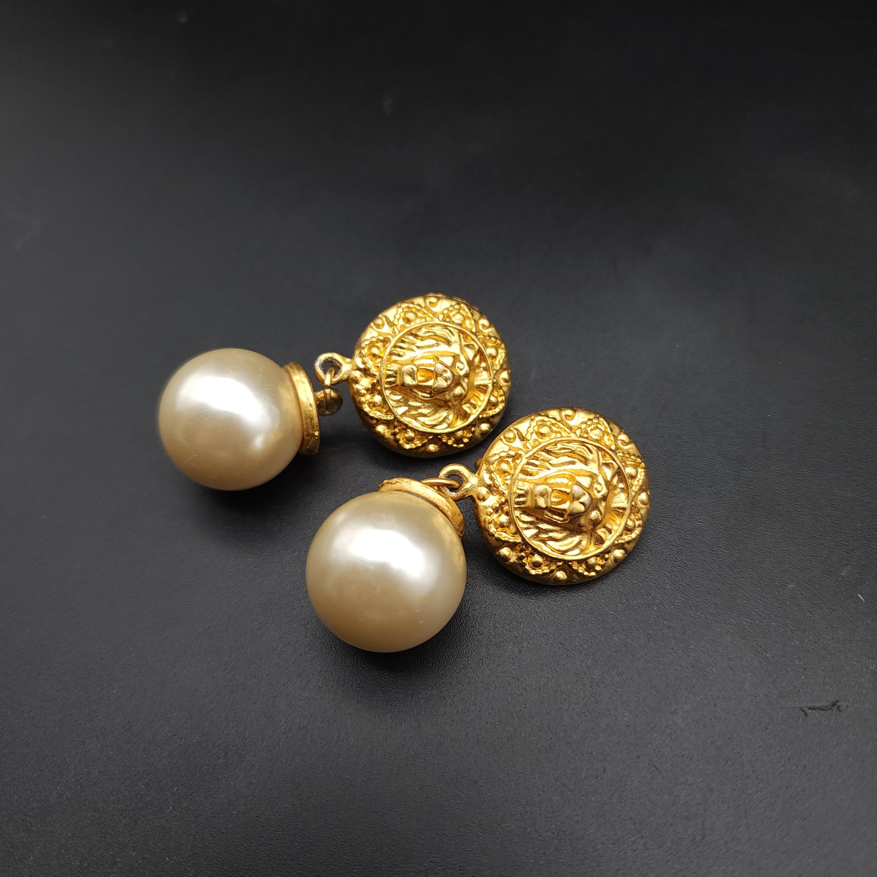 Dimensions: 5 cm x 2.3 cm each approx

Unleash the majesty of vintage style with the golden-tone lions head clips, featuring large, opulent faux pearls that dangle with regal elegance. These retro-inspired earrings showcase a bold lions head motif,
